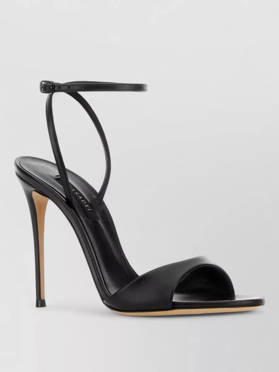Casadei Leather sandals — The Casadei black stiletto sandal is minimal and sleek, matching the dress’s sharp tailoring and the cardholder’s polish without adding visual weight.