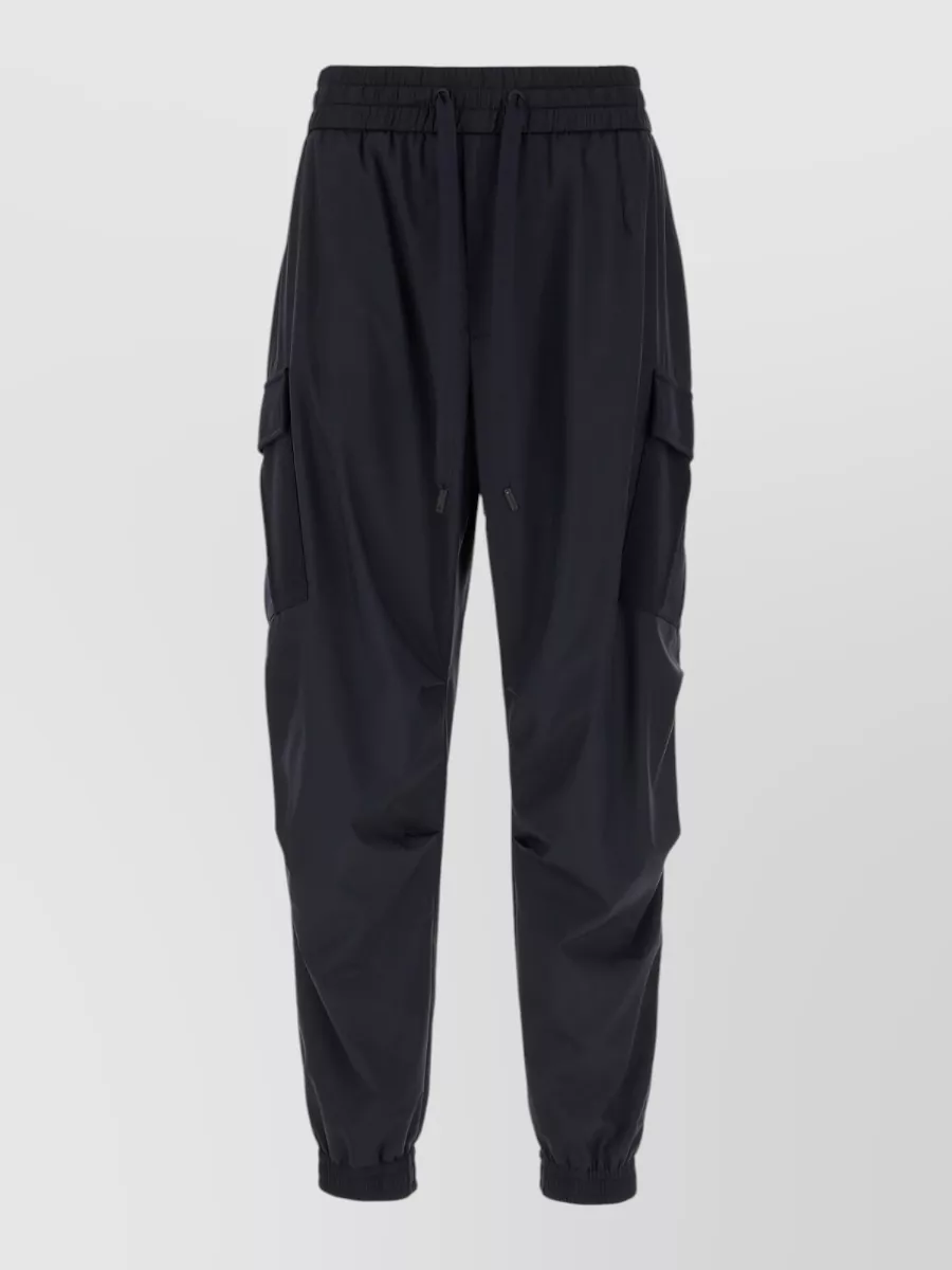 Dolce&Gabbana Track pants — Technical black cargo joggers in D echo the sneaker’s sporty attitude, give a tapered cuff to sit perfectly on the chunky sole, and keep the overall line sleek and city-ready.