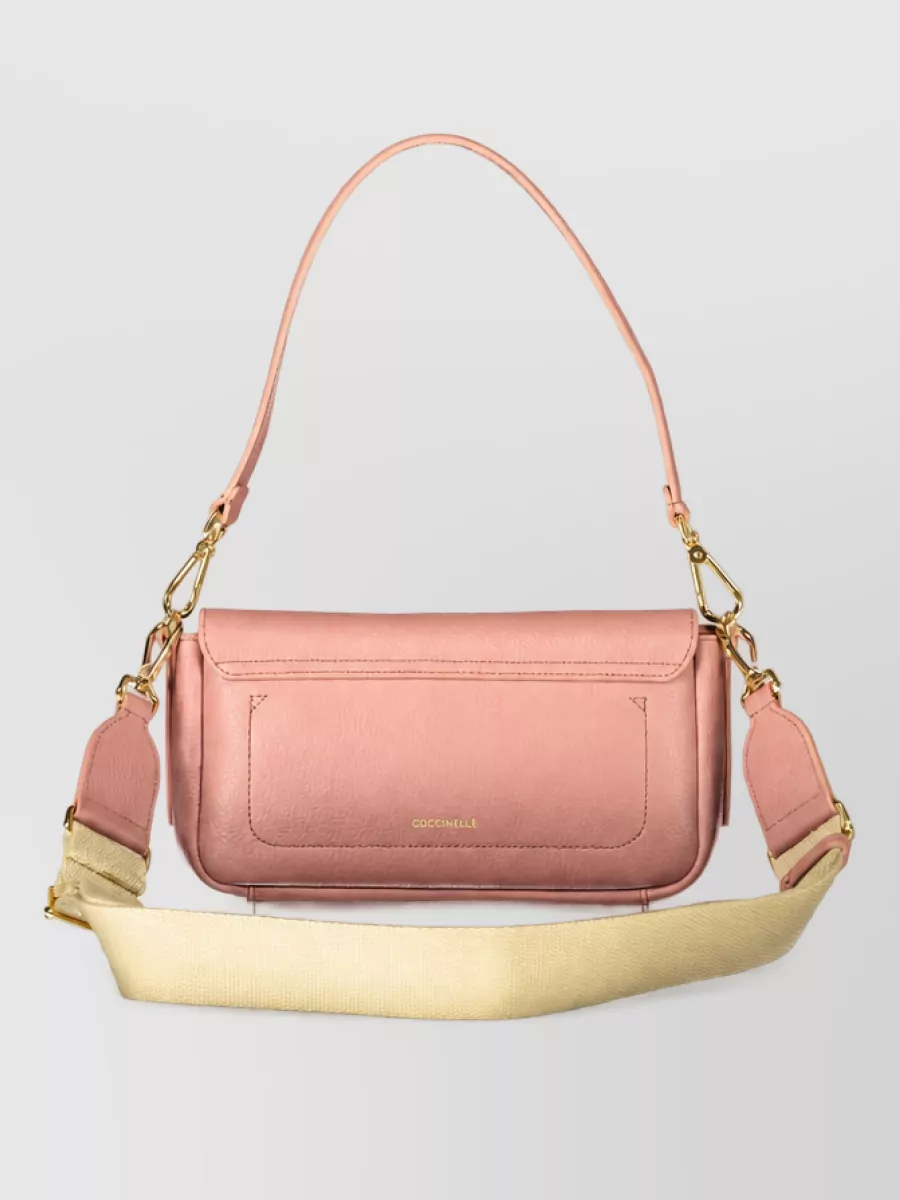 Coccinelle Leather clutch bag — The Coccinelle dusty-rose mini flap stays within the soft blush family, brings quiet polish in a structured shape, and aligns with the romantic-preppy aesthetic and mid luxury tier of the outfit.