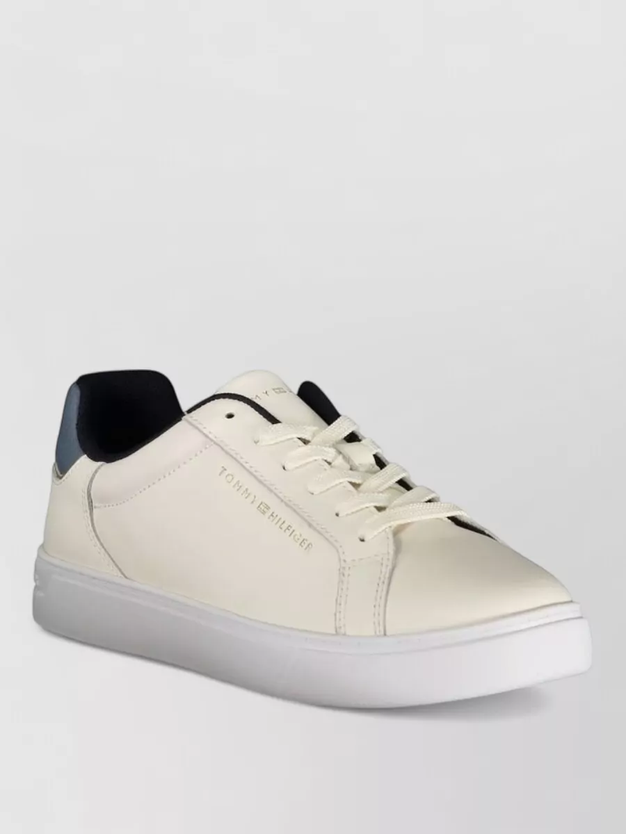 Tommy Hilfiger Low-top lace-up sneakers — The clean white Tommy Hilfiger sneaker hits the minimalist preppy note, keeps formality casual-smart, and balances the slim ankle trouser for a fresh, city-ready finish.