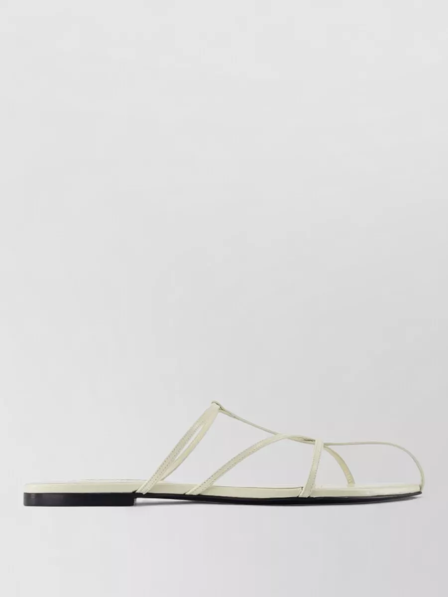 Jil Sander Leather pointed-toe sandals — The Jil Sander buttercream strappy slides keep the outfit minimalist and quietly polished, match the summer weight of the shirtdress, and maintain a light preppy attitude without competing with the dress.