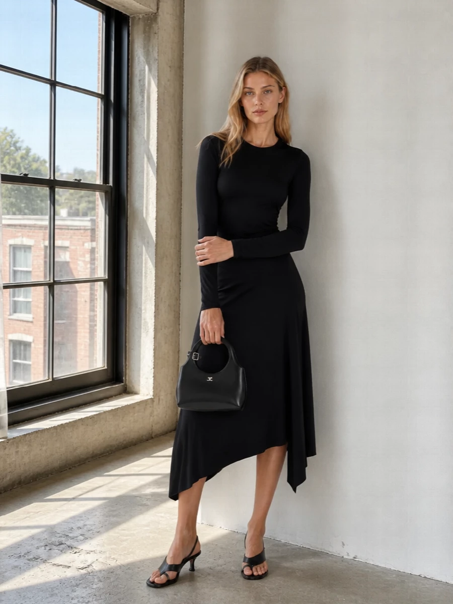 A deep black Victoria Beckham midi dress and the Courrèges top-handle bag create a sculpted, monochrome column that feels precise rather than heavy. The asymmetric hem and circular handle add just enough movement, while Totême’s low kitten-heel slingbacks keep the line long and modern for city evenings. Choosing the dress route over separates lets the bag read as a considered object, not an afterthought, which suits this level of quiet luxury best.