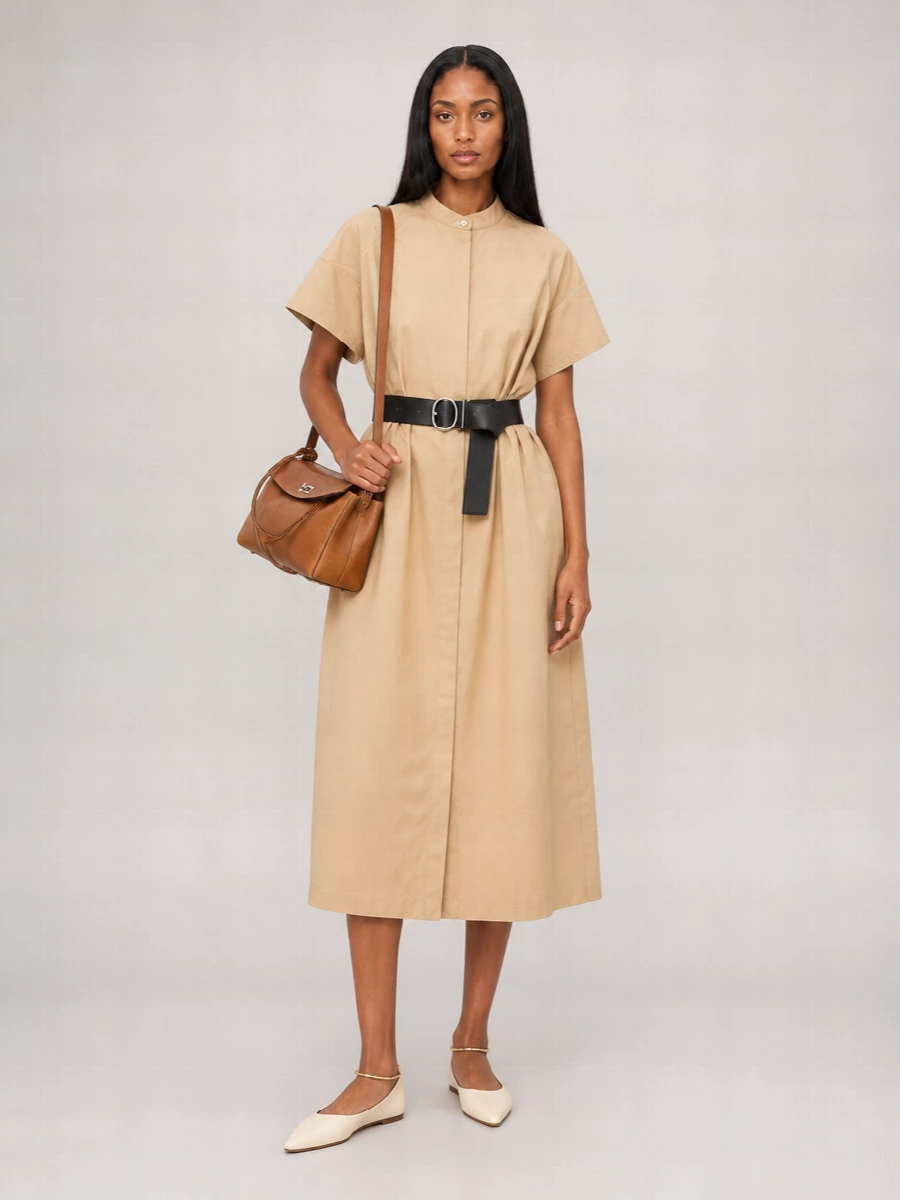 A sand-beige shirt dress and buttercream pointed flat create a softly structured column that feels precise but relaxed. The warm neutrals echo the cognac top handle, keeping the palette calm and cohesive. Choosing the dress route over tailoring separates lets the bag stay central, ideal for days that blur from errands to low-key dinners without a change.