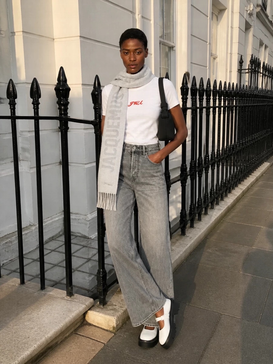 Pair the crisp JW Anderson logo tee with Alexander Wang’s high waisted washed grey wide leg jeans for a clean, easy streetwear uniform that still feels considered. Chunky off white Mary Janes and a sculptural black shoulder bag sharpen the silhouette, keeping the palette tight and graphic while letting the tee’s red logo stay the quiet focal point.