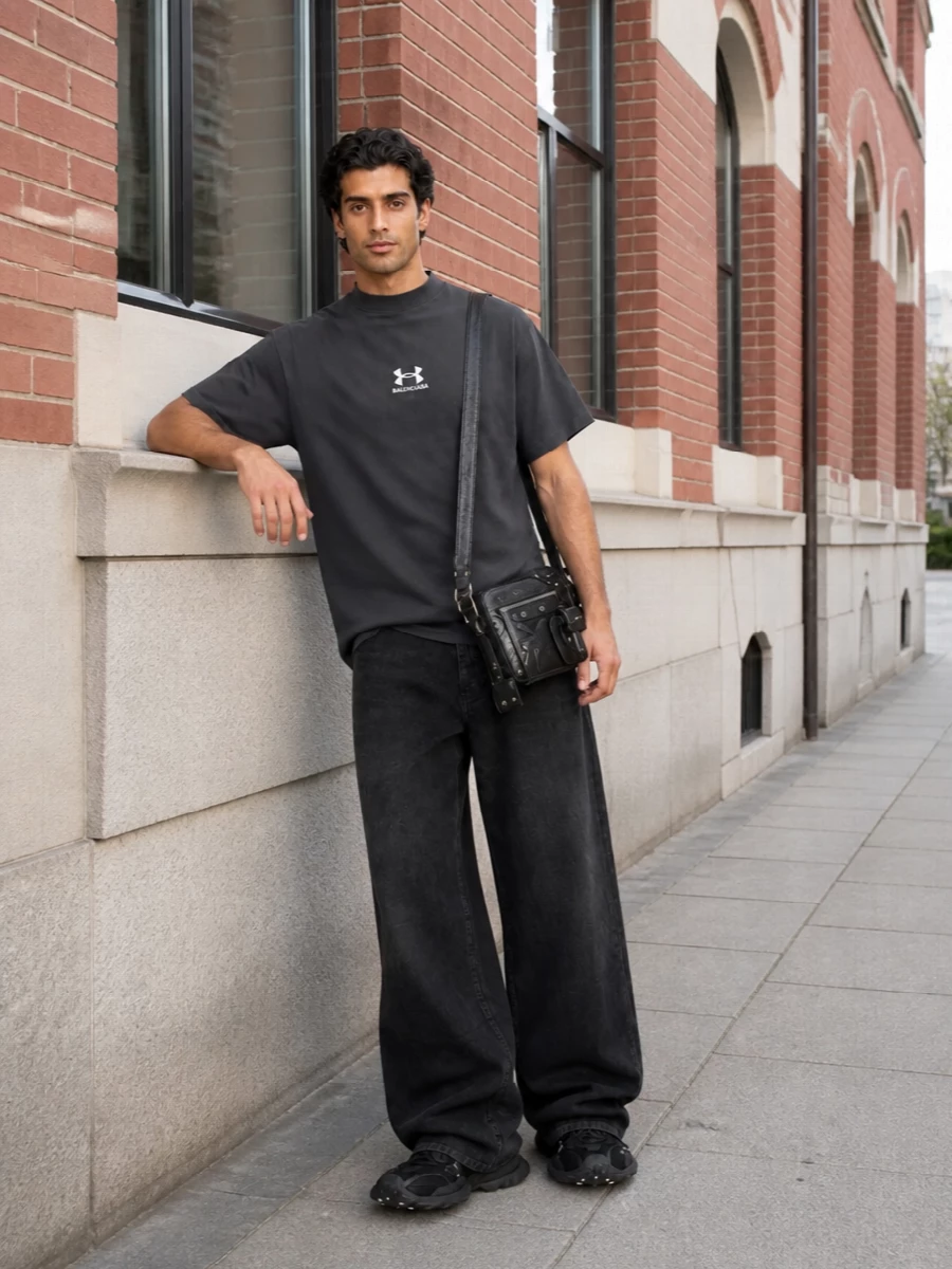 Balenciaga’s technical sneakers, boxy high‑neck tee and high‑rise wide‑leg denim build a tight black and charcoal palette with a strong, graphic silhouette. The slouched jeans pool over the sculpted runners, while the structured tee keeps everything feeling deliberate and modern. The compact crossbody adds just enough hardware and texture for a city‑ready finish without breaking the sport‑driven mood.