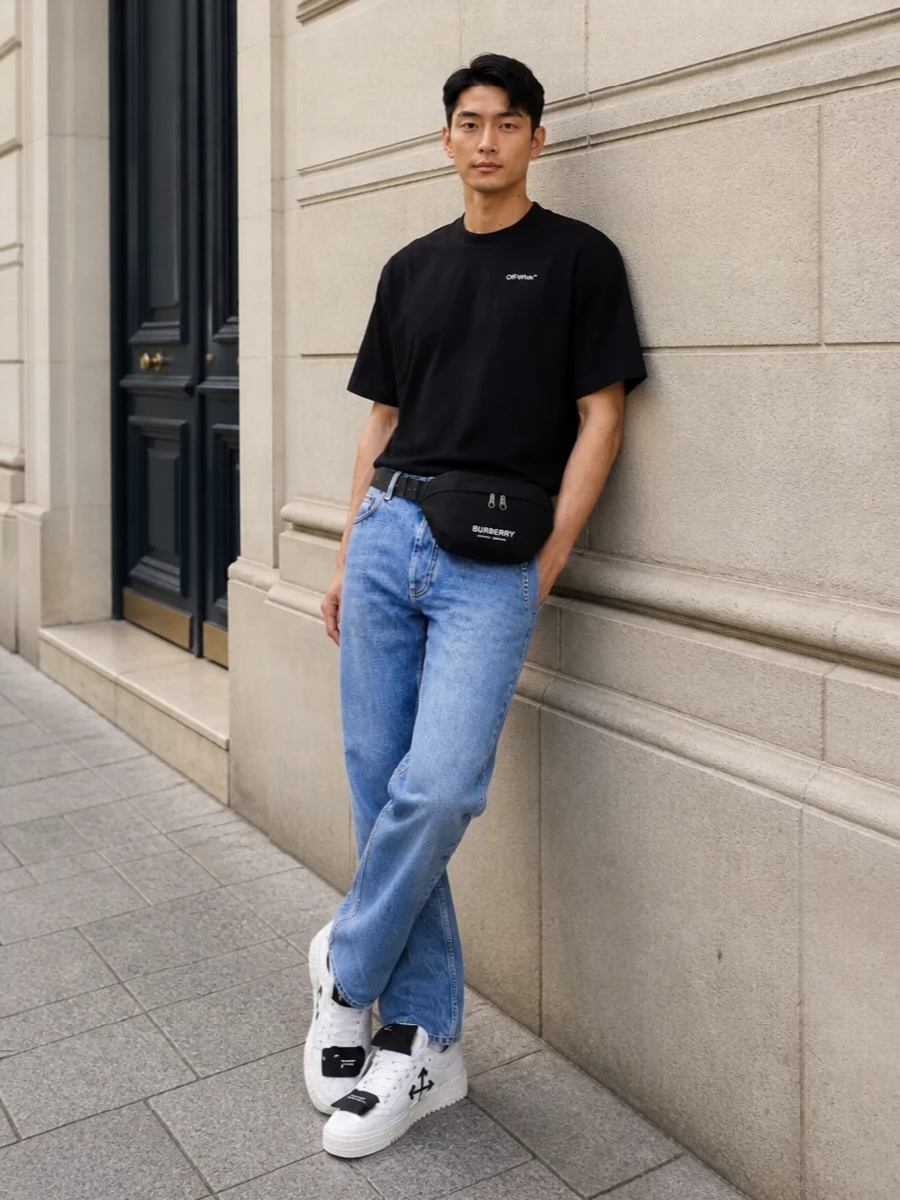 This look keeps the focus on a sharp, boxy black Off-White tee grounded by light-wash straight-leg denim for that effortless, SS-ready streetwear contrast. White Off-White sneakers and a black Burberry belt bag keep the lines clean and graphic, while the Prada belt adds just enough polish at the waist without disturbing the minimalist attitude.