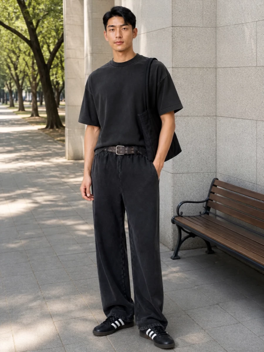 Washed black on washed black keeps this entire set calm and grounded, letting the volume of the tee and trouser do the work. The terrace trainers and grommet belt sharpen it just enough, while the Porter tote brings a functional, technical note that feels right for city days. It is an easy uniform: loose, monochrome and quietly precise in its proportions.