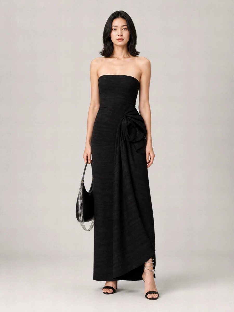 A darkly romantic evening ensemble built around a sculpted strapless black column that lets the Rene Caovilla spiral sandals feel like jewelry. The clean, floor-length line and subtle ruffled texture are quietly cinematic, while the black crescent bag with silver chain picks up the shoe’s shimmer in a controlled, modern way. This path beats separates here, because a single continuous column best showcases the ankle detailing and keeps the drama focused where it belongs: on movement and light around the hem.