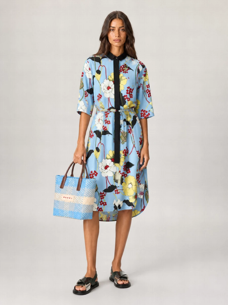 I chose the dress route so the Marni floral shirt dress can fully dialogue with the checked tote, creating a single, artful print story instead of breaking it up with separates. The sky blue ground and fluid cut feel light and boho, while the structured tote and flat color-block sandals keep everything practical for warm city days or travel. It is an easy throw-on combination that still feels distinctly designer and optimistic in its color.