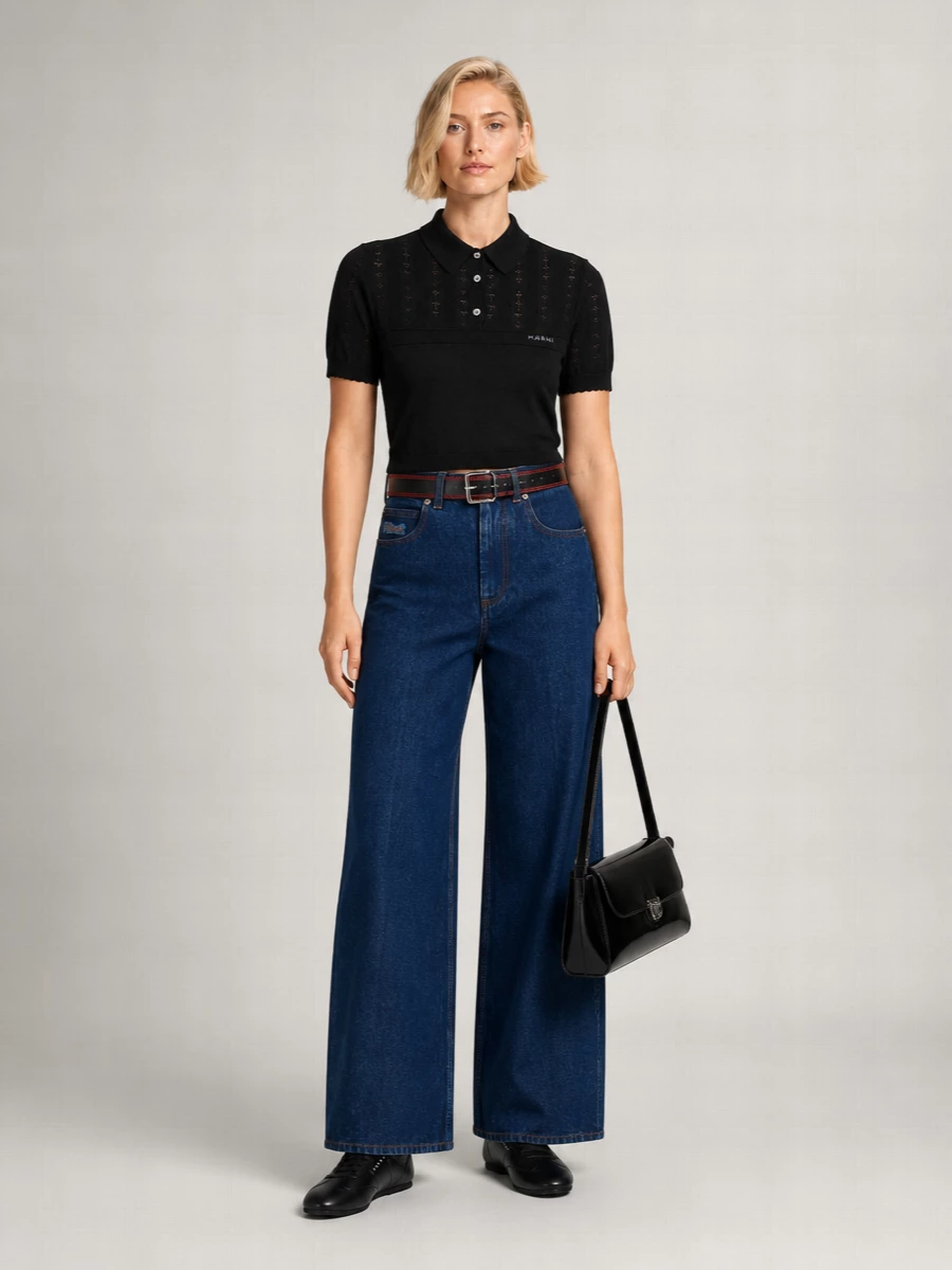 I am building around separates rather than a dress so the belt can function as a visible, intentional anchor at the waist of the wide-leg denim. The result is a minimalist Marni uniform in deep indigo and black, with subtle red and metallic hits reading as quiet attitude rather than decoration. Proportions stay clean and modern, with the cropped polo, high-rise jeans, sleek sneakers and structured bag forming a coherent city outfit for cool-weather days that move easily from gallery to dinner.