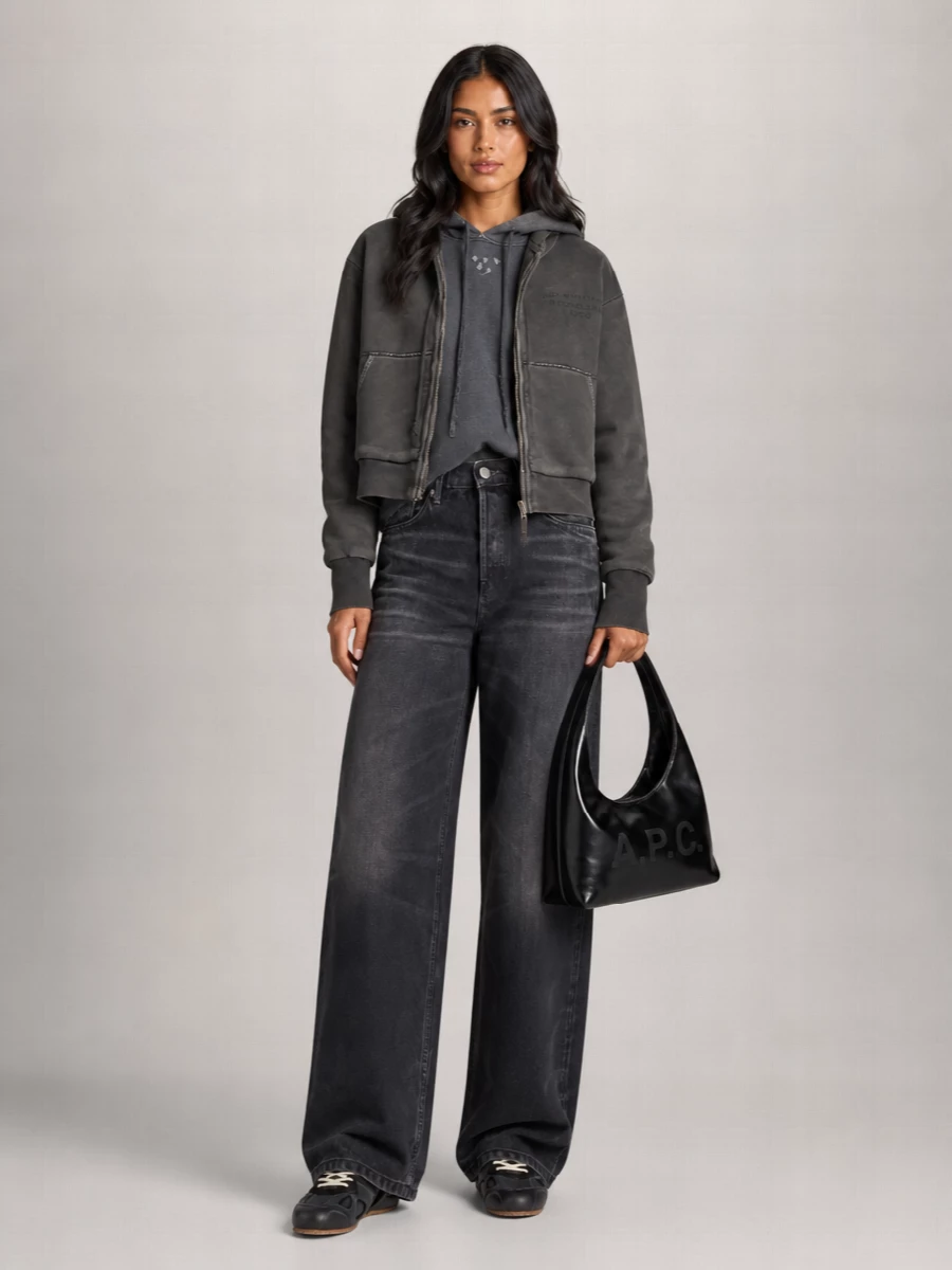 I am building around denim rather than a dress, because the cropped Acne hoodie really wants that long, wide-leg proportion to feel modern and grounded. The washed charcoal jeans, tonal hoodie and dark sneakers create a tight grey-black scale that reads minimalist and street but still grown-up, with the structured hobo adding a quiet, polished finish. It is an easy city uniform for colder days that relies on proportion and texture instead of color to feel considered.