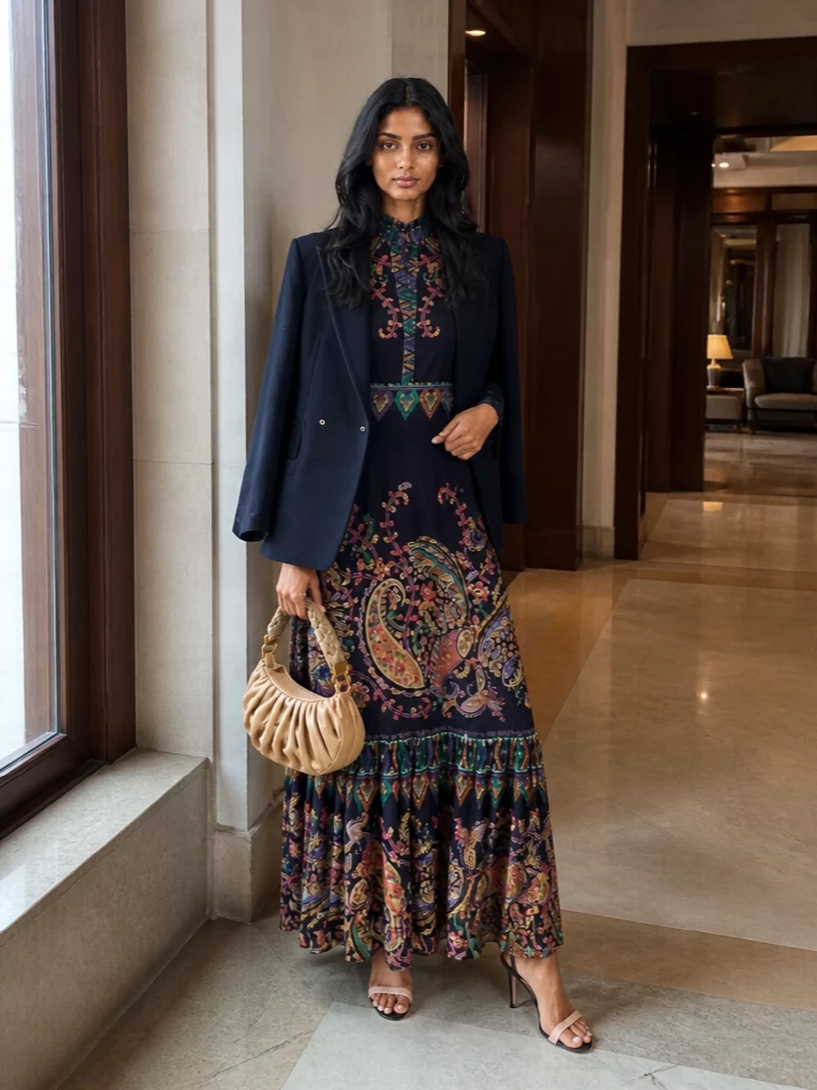 A richly patterned Etro maxi becomes the star, grounded by slim black-and-blush sandals that echo its dark base without adding more noise. A softly structured sand crescent bag brings warm, understated texture, keeping the mood romantic and polished while letting the paisley do the talking.