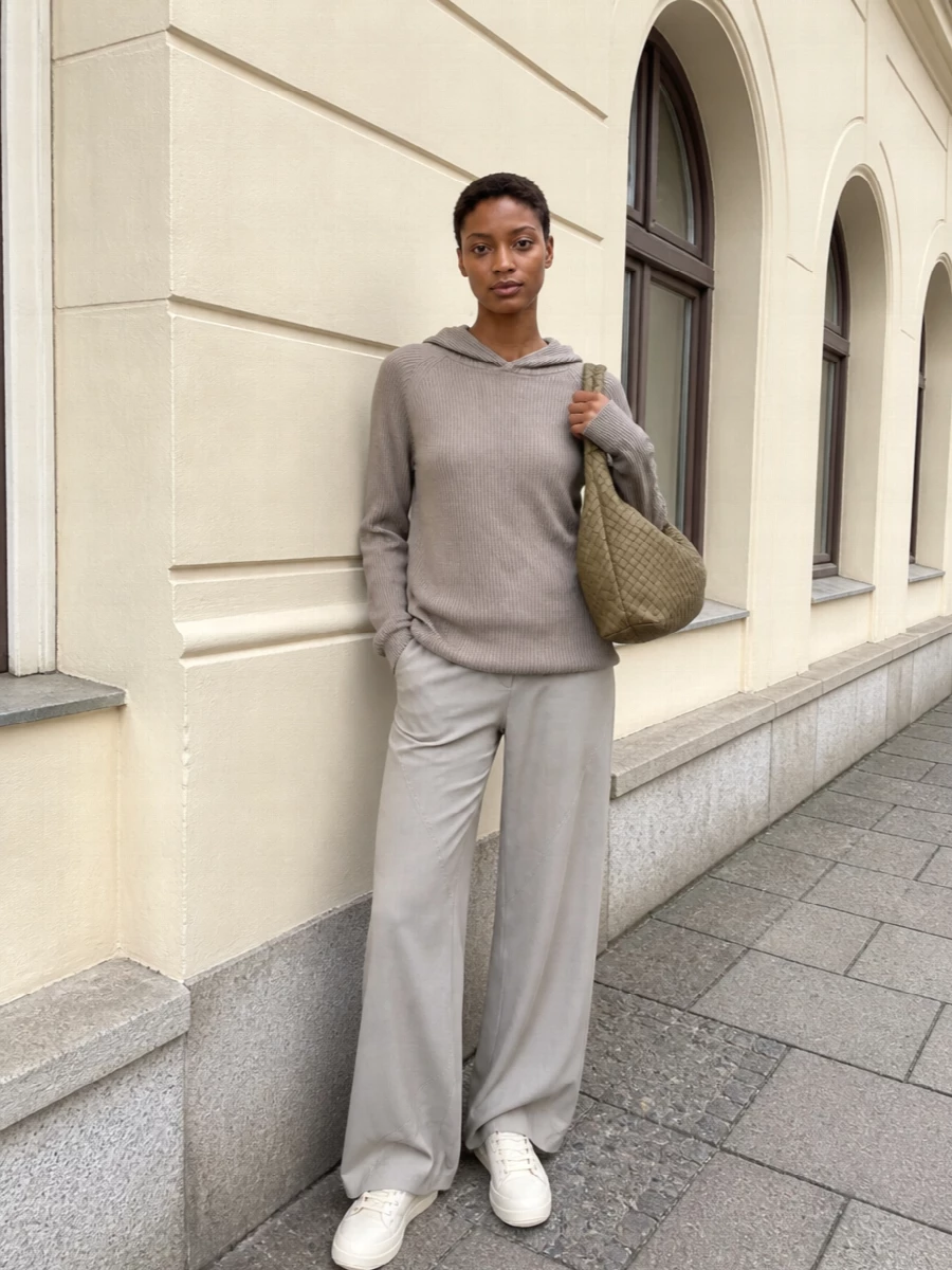 A taupe ribbed hood meets matching wide-leg trousers for a long, cocooned column in soft neutrals. Chunky ivory hi-tops ground the fluid lines with a sculptural edge, while the slouchy woven hobo keeps everything relaxed but deliberate. The result is low-key Rick energy for days when you want ease, texture, and quiet presence rather than contrast.