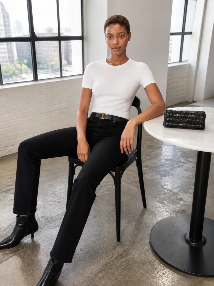Soft white Totême jersey with high-rise black denim creates a quiet, graphic base that feels precise but easy. Pointed ankle boots and a structured black bag add just enough sharpness while the slim belt finishes the line at the waist. It is a quietly confident uniform you can take from studio days to understated dinners without changing a piece.