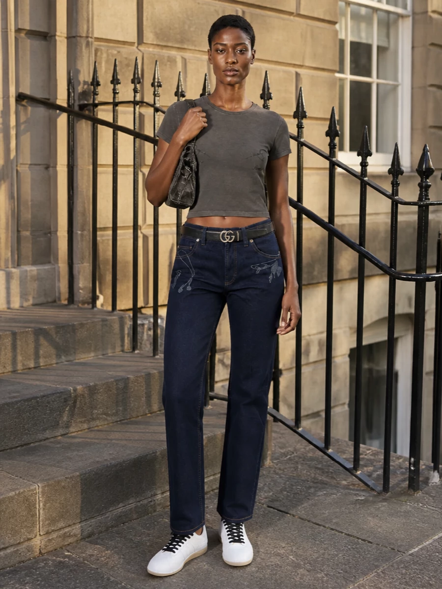 Washed charcoal Gaultier meets dark indigo denim for a graphic but low-key take on Y2K streetwear, all in a tight black-grey-blue palette. Sleek Y-3 sneakers and a charcoal Marc Jacobs mini bag keep the vibe city-ready, while a slim Gucci belt quietly sharpens the mid-rise line. It is an easy, confident uniform for off-duty days that still reads distinctly designer.