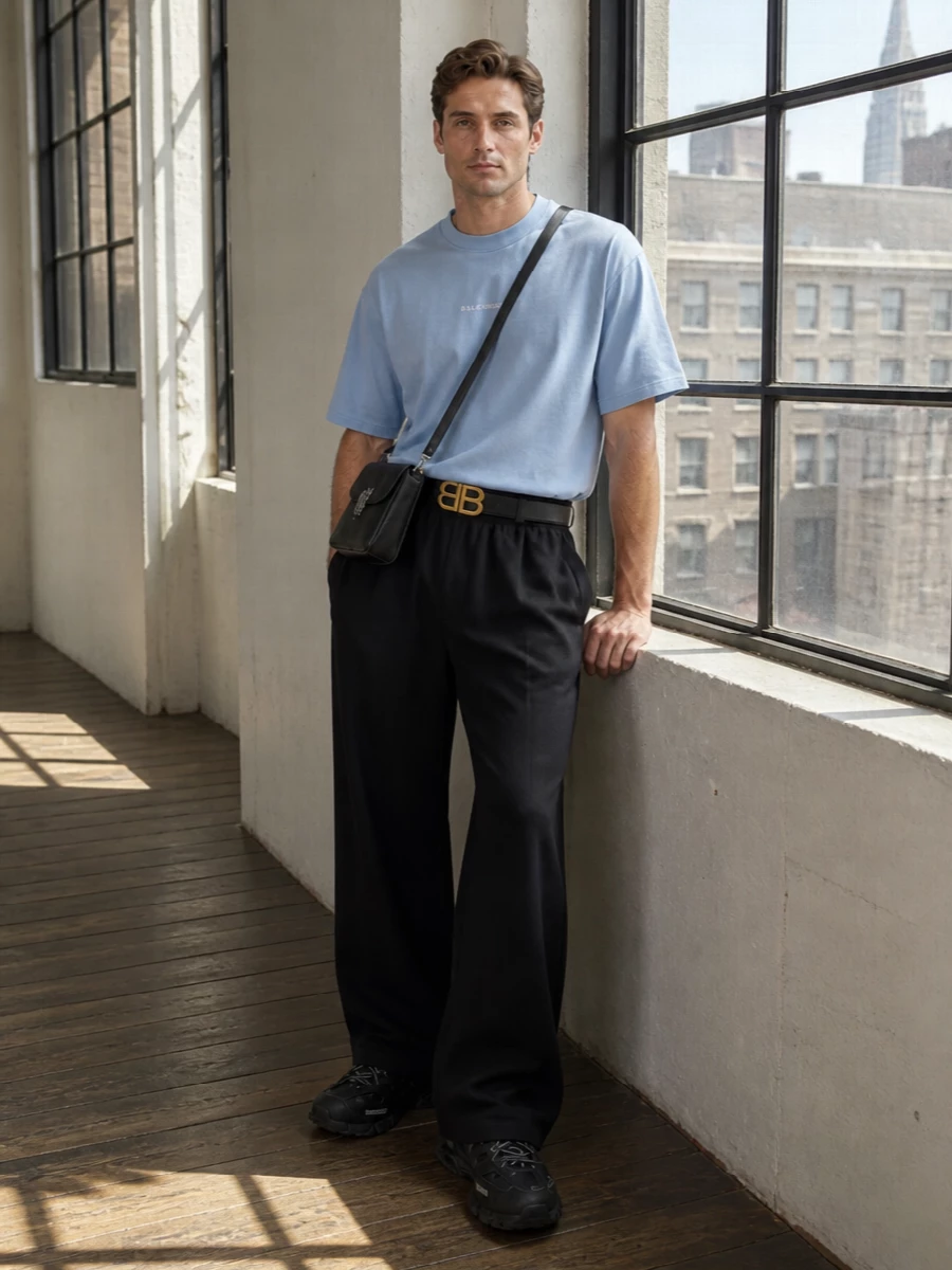 Pale blue sits against deep black for a calm, graphic take on Balenciaga streetwear, with the tee’s softness balanced by full, easy volume through the trouser. Chunky black runners keep the shape grounded and athletic, while a structured crossbody and sharp belt add just enough polish for low-key city days and late evenings out.