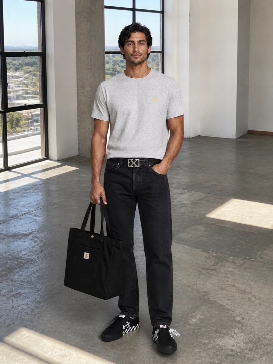 A heather grey Carhartt tee sits against washed black straight-leg denim for a clean, utility-driven base. Graphic Off-White sneakers and a matching arrow-buckle belt inject just enough street energy while the black Carhartt tote keeps everything grounded and functional. The result is relaxed workwear with a precise, logo-smart finish that moves easily from campus to city laps.