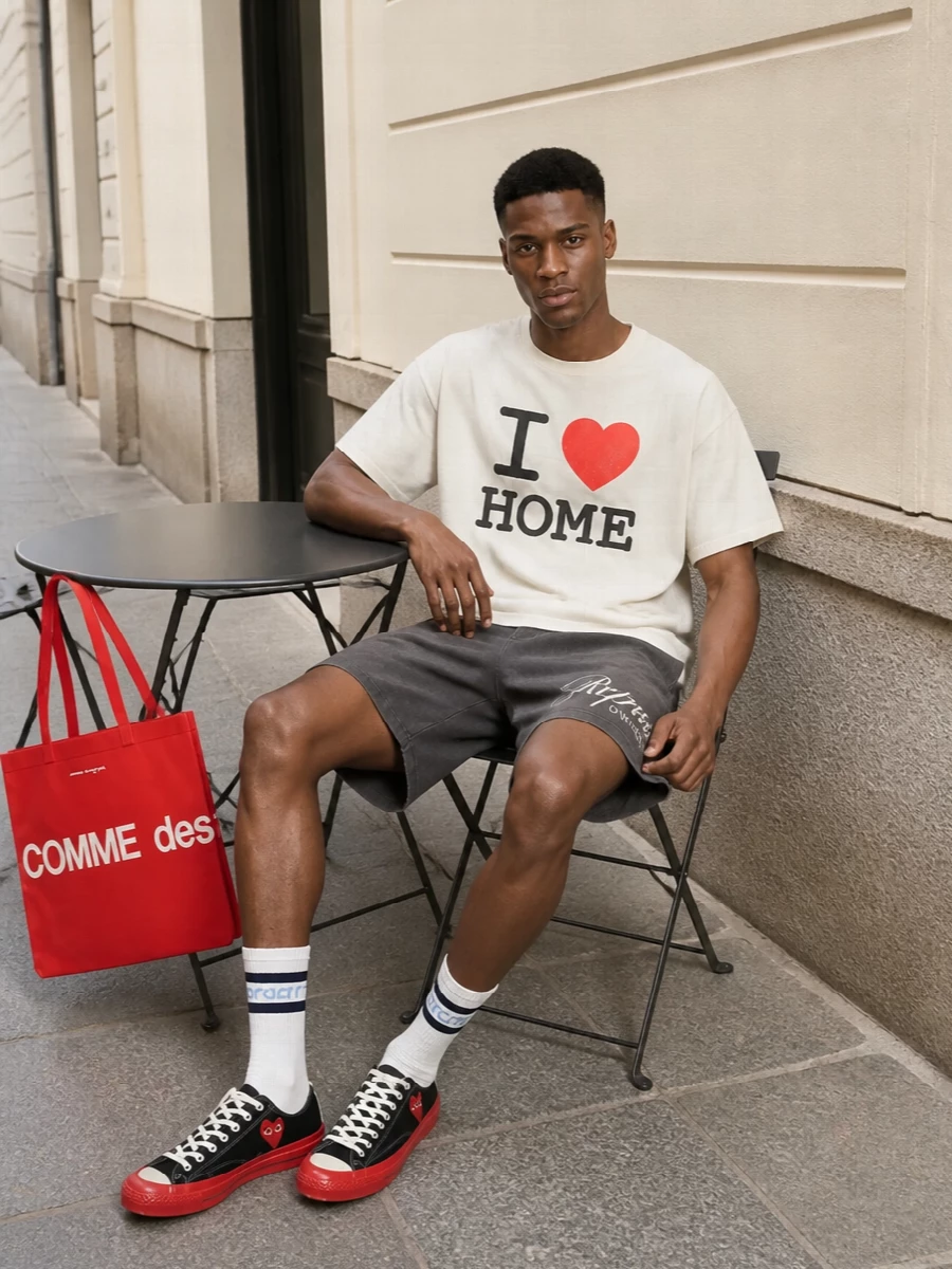 Graphic but relaxed, this mix keeps the Gallery Dept. tee as the focal point and builds around its off-white and red with washed charcoal and clean black. The Represent shorts keep the silhouette loose and easy, while the Play sneakers and bright CDG tote echo the heart motif in a sharper, street-led way. Collegiate striped socks finish it with a discreet sport cue rather than another loud logo hit.