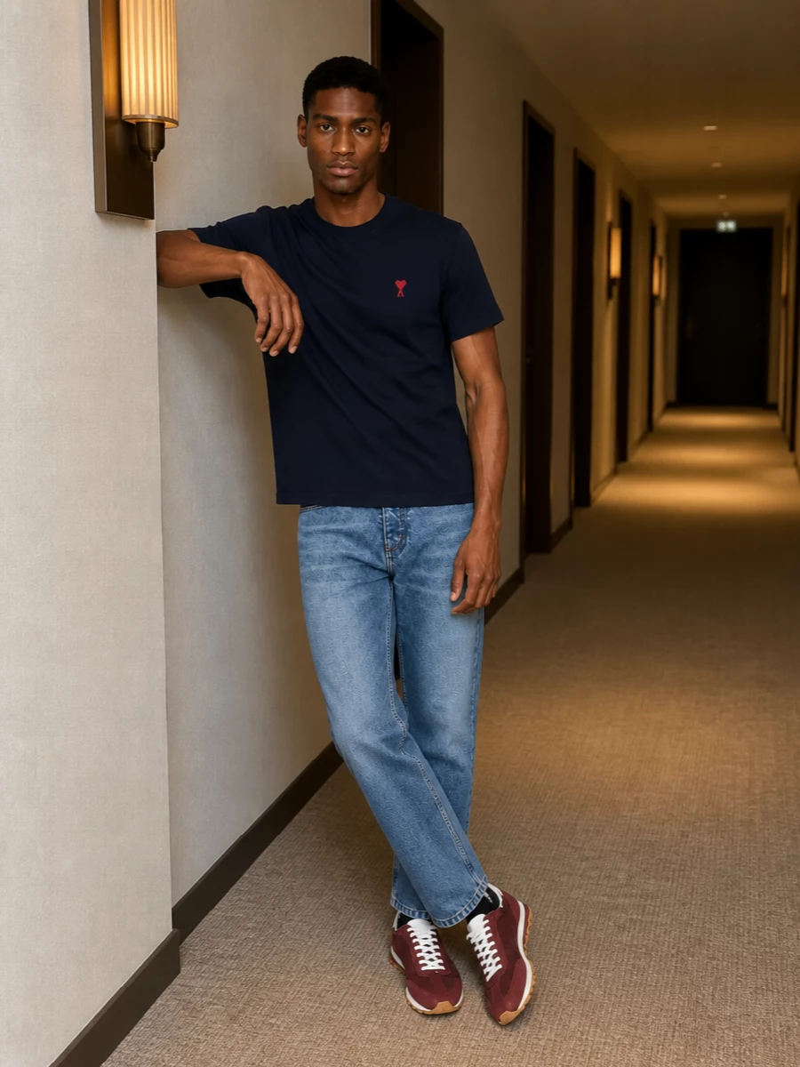 Navy and mid blue set an easy Parisian base here, with the straight-leg denim keeping the tee relaxed but still sharp. Burgundy runners pick up the tiny hit of red at the chest, while black accessories ground everything in a clean, city-ready way. It is a simple uniform that reads considered rather than trying, ideal for all-day wear from coffee to late trains home.