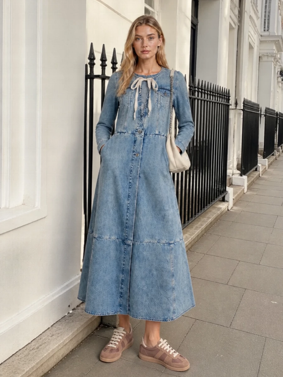 Maison Margiela denim and sneakers meet in a soft, neutral story, with buttercream and mauve playing quietly against washed blue. The long A-line dress stays the focus, grounded by low-profile trainers and a padded shoulder bag that echo its deconstructed ease rather than competing with it.