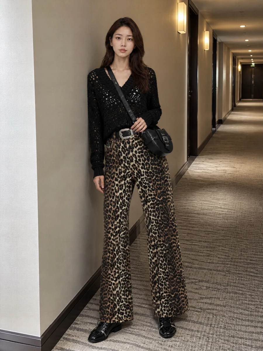 Leopard wide-leg denim takes center stage, grounded by a slouchy black open knit that lets the print feel intentional rather than loud. Tough lace-up boots and a sharp crescent cross-body keep the palette tight in black, so the jeans feel streetwise and grown-up. A subtle Western-influenced belt nods to the pattern’s wild side while quietly cinching the high rise for balance.
