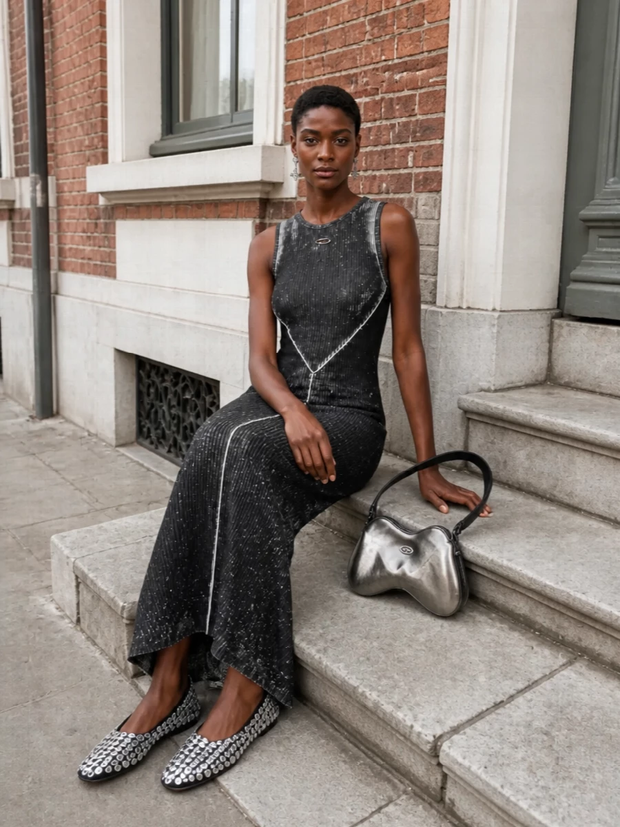 I’m taking the dress route here, because the Diesel metallic maxi and orbit earrings together create a cohesive, graphic, almost cyber club narrative that a top and skirt combo would dilute. The ribbed, body-hugging dress and flat disco-ball ballerinas balance drama with comfort, keeping the shine concentrated on metal and crystal rather than loud color. The sculpted gunmetal bag finishes it as a tight, monochrome night-out story that still feels very now and very y2k in spirit.