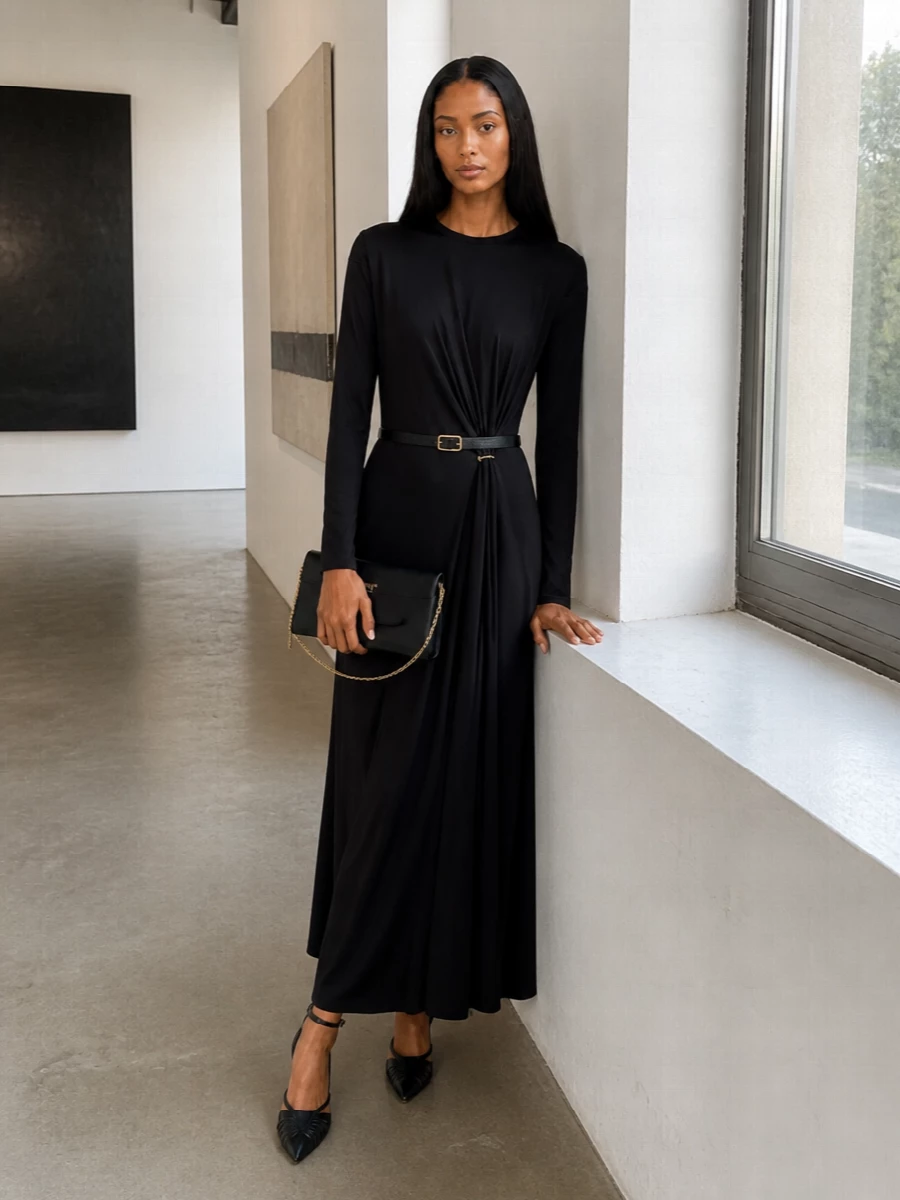 Pared-back black and precise gold details keep this evening ensemble focused on line and movement. The strappy pump and structured clutch echo the dress’s gathered waist and hardware, creating a single, uninterrupted column. Add the slim belt only if you want a touch more definition at the waist without disturbing the clean drape.