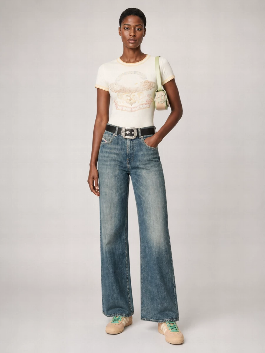 A softly faded Diesel tee meets high-waisted wide-leg denim in washed blue for an easy, lengthening Y2K silhouette. Pastel sneakers and a pistachio shoulder bag keep the palette light and nostalgic, while a cherub-buckle belt quietly ties the graphic story together. The result is relaxed streetwear that feels playful but still grounded enough for all-day city wear.