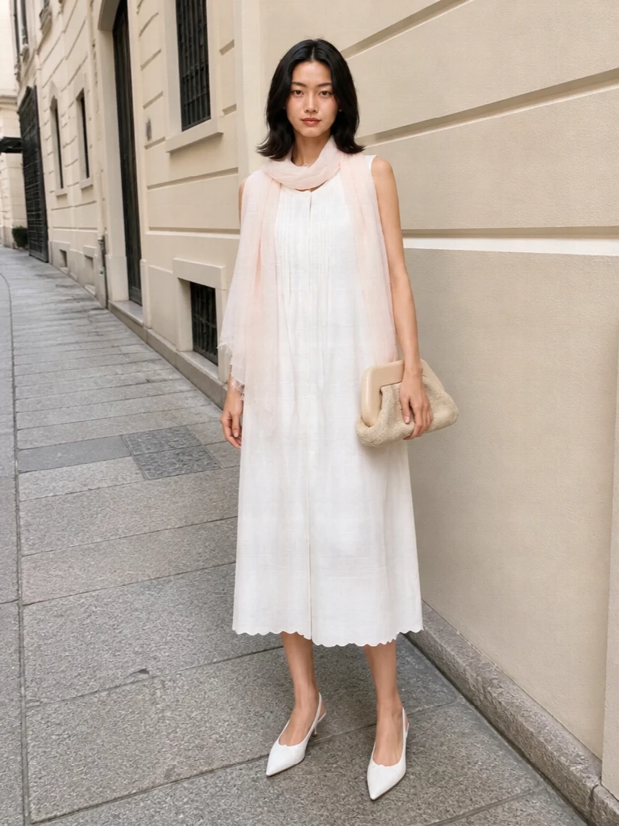 An ivory-on-ivory story keeps the nightdress feeling intentional rather than purely loungewear, with the kitten-heel slingback and framed clutch adding just enough structure and shine. Pearls and a gauzy blush scarf bring a gentle glow around the face and shoulders, so the whole ensemble reads like soft, modern romance for slow warm days and unhurried evenings.