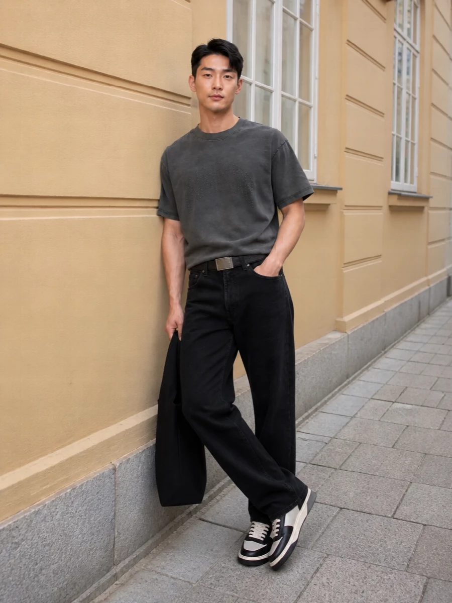 Charcoal-on-black keeps this outfit tight and focused, letting the studded tee sit as the only overt texture up top. Straight black denim and a slim leather belt give just enough structure, while the monochrome low-top and soft tote keep the mood grounded and street led. It is an easy uniform you can wear hard without it ever feeling busy or branded-out.