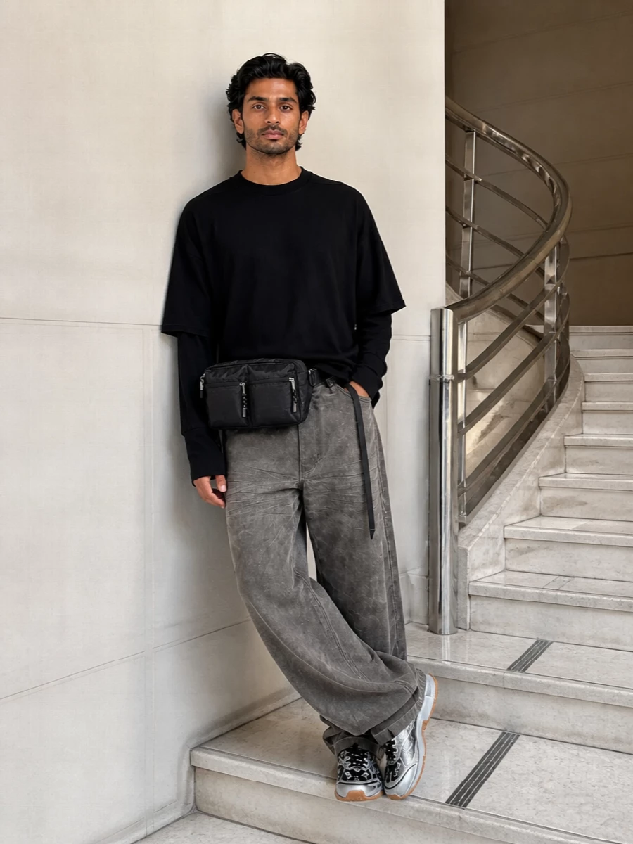 A dark, DRKSHDW-inflected uniform built around volume and texture, with the sneakers cutting through in silver and gum for a technical jolt. The layered black top and taupe-grey wide denim create a slouchy, graphic line, while the belt bag keeps the whole thing practical and city ready without softening the attitude.