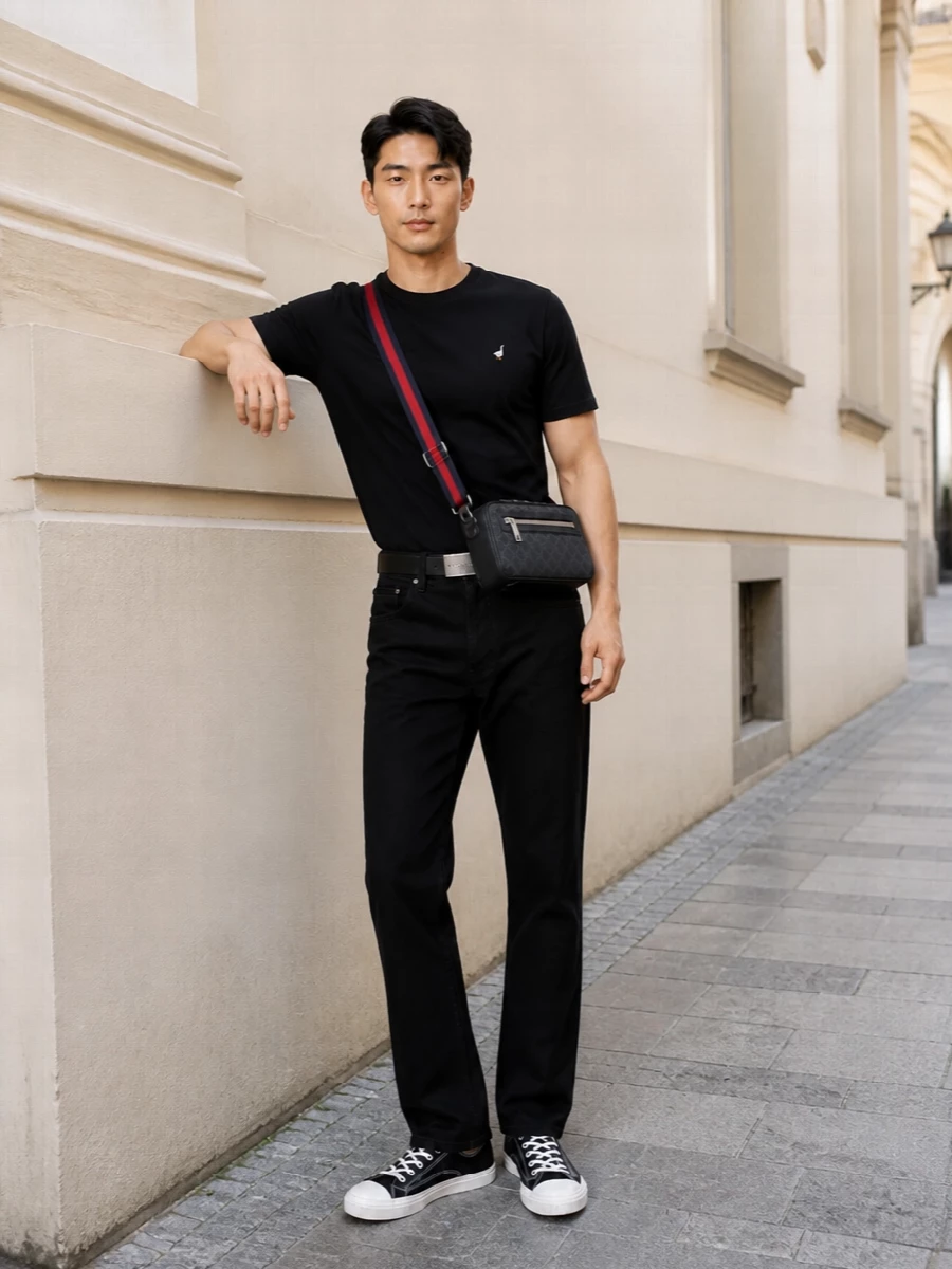 A clean black-on-black base lets the goose tee do the talking, with straight-leg denim keeping the line easy and unfussy. Canvas sneakers and a compact crossbody keep it grounded in the city, mixing quiet branding with laid-back street energy. The result is casual, graphic and precise without feeling styled within an inch of its life.
