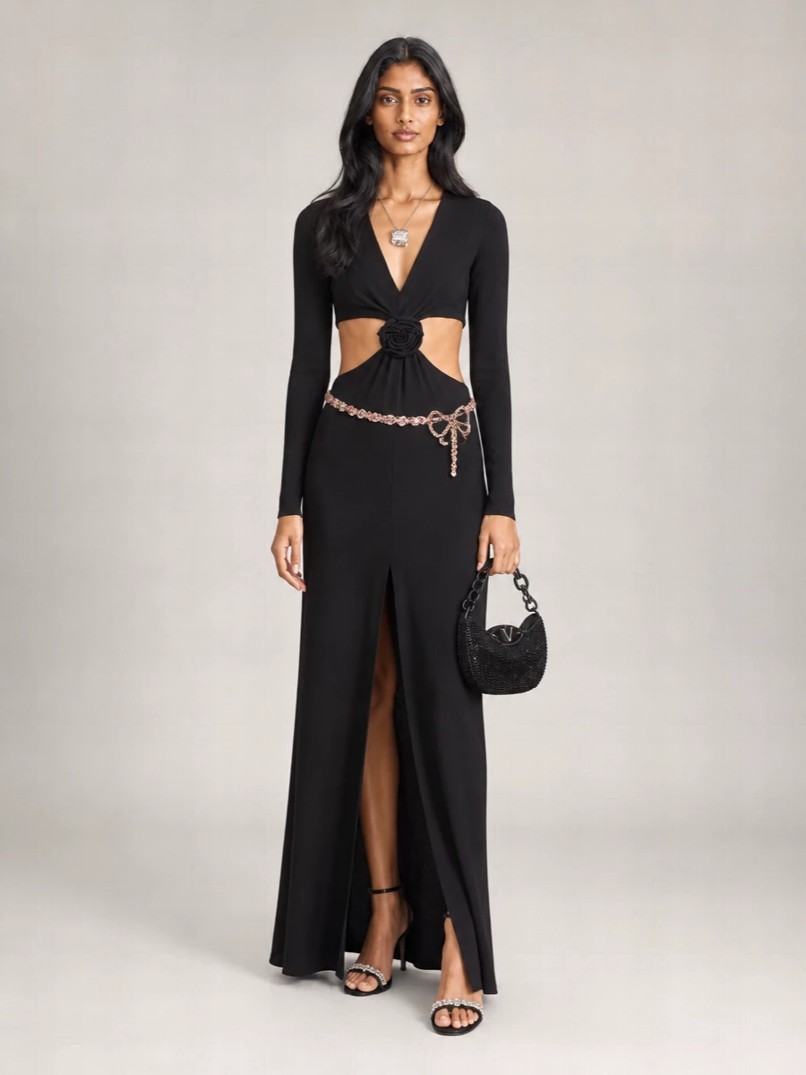 A black-on-black evening story keeps the focus on Blumarine’s cut-out maxi, with every accessory adding light through crystals rather than competing color. Strappy stilettos, a beaded mini hobo and a fine crystal belt elongate and trace the body, reinforcing the dress’s long, sensual line. A single sculptural pendant finishes the neckline with just enough shine to feel considered, not crowded.