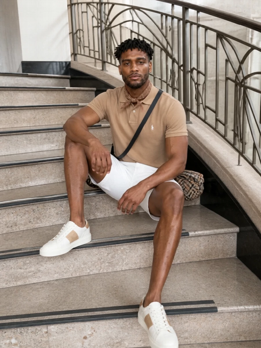 Camel, optic white and warm neutrals keep this combination sharp yet relaxed, a polished nod to classic East Coast prep. The tailored short and quietly branded sneakers align on clean lines and soft structure, while the Burberry crossbody and camel silk square add just enough texture to feel considered without trying too hard. It is an easy warm‑weather uniform for terrace lunches, coastal weekends and relaxed city days alike.