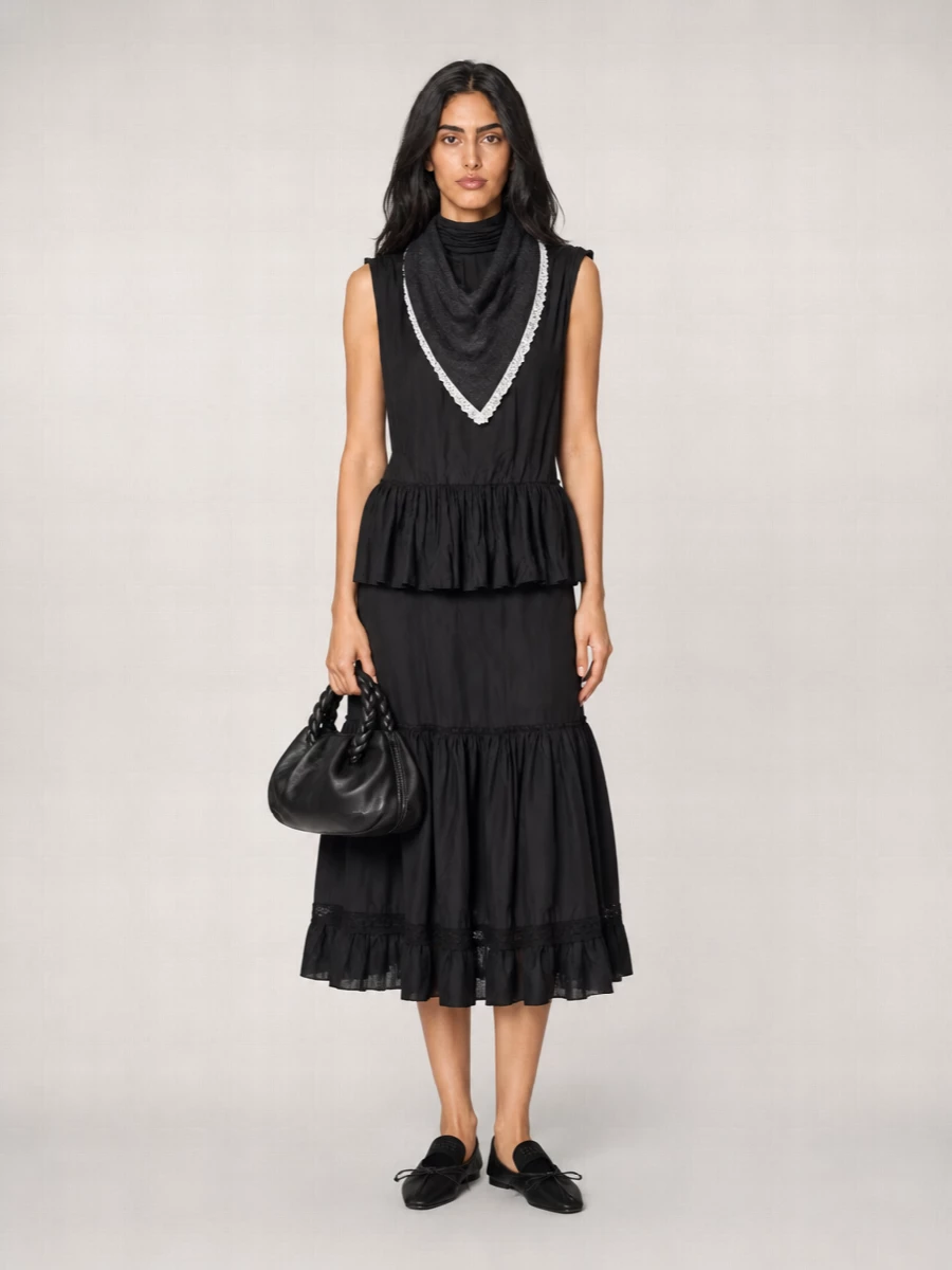 A black-on-black story that leans into movement and texture, pairing the ruffled tunic with a tiered midi for a long, soft column. Sheer pointed flats keep it grounded and modern, while a sculptural mini tote and lace-trimmed scarf add just enough romance without breaking the minimalist mood. Ideal for cooler days when you want drama that still feels easy and wearable.