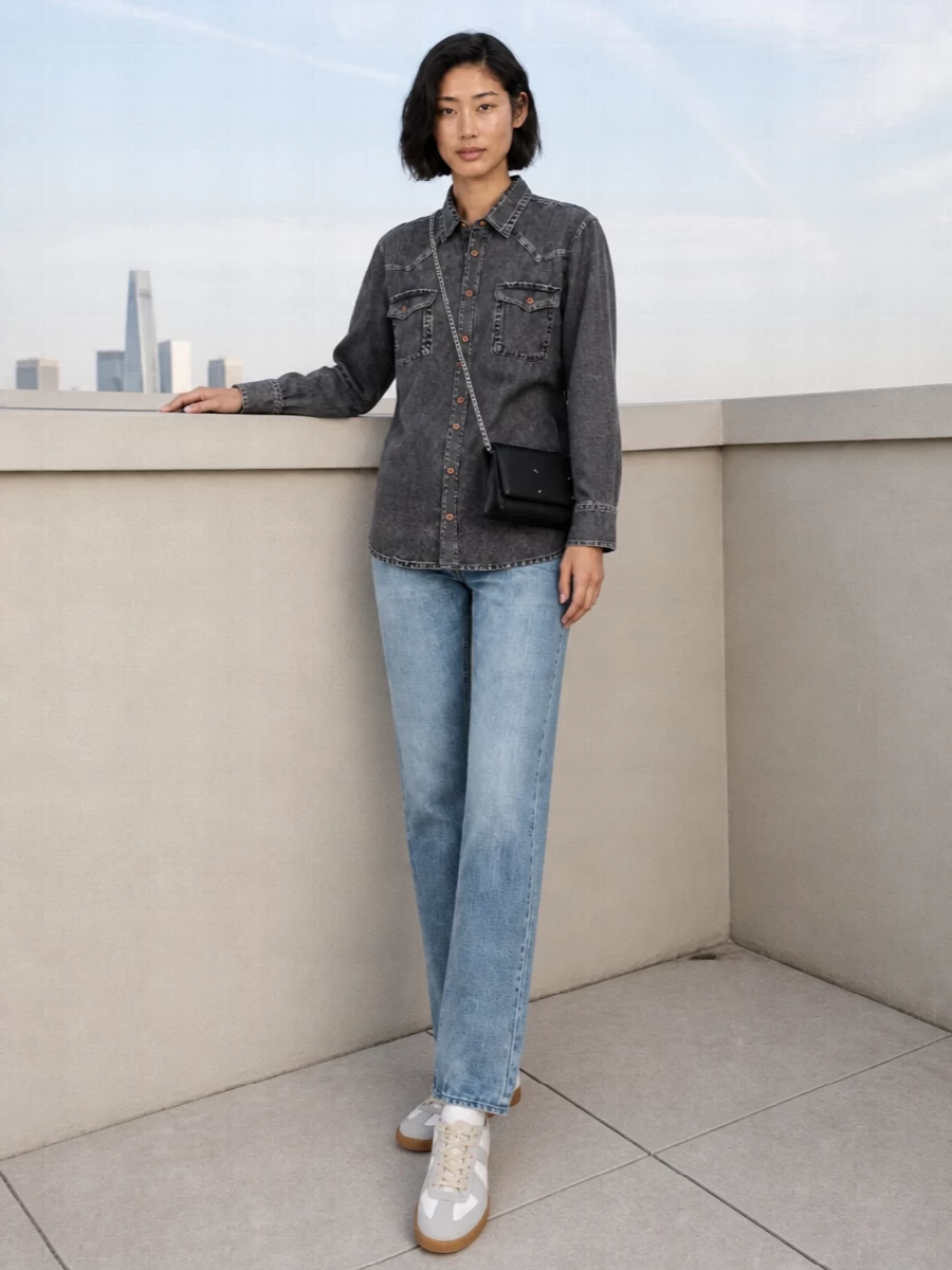 Charcoal denim shirting meets a light, straight-leg jean for a clean, slightly androgynous double-denim uniform. Soft white Margiela sneakers keep the lines relaxed and modern, while a compact black crossbody and chalked-number scarf add just enough conceptual edge. The result is easy streetwear with a quiet, intellectual twist that still feels ready for real city days.