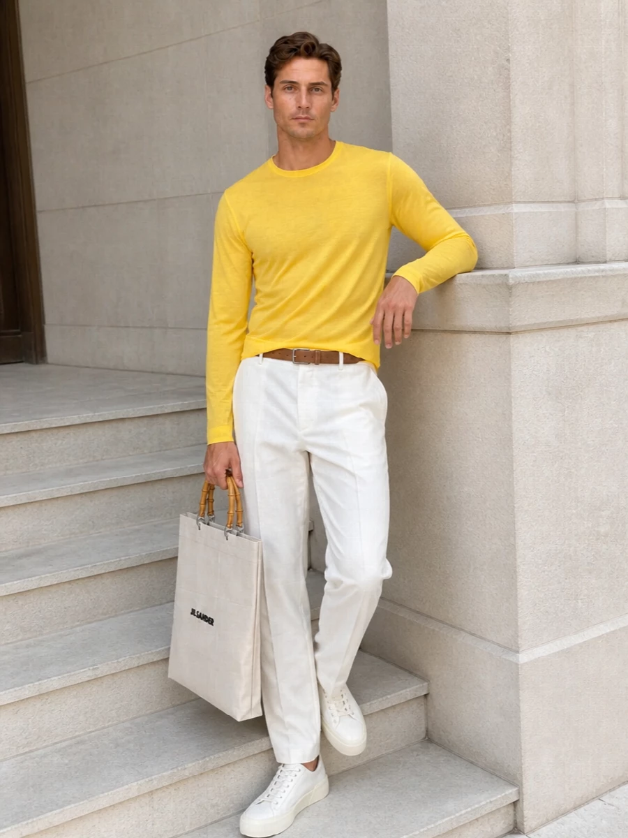 A sunlit yellow sheer layer sits over soft off white pleats for a clean, tonal take on summer minimalism. The pale canvas sneaker and structured tote keep everything light and precise, while the camel suede belt quietly anchors the proportions. It is an easy gallery afternoon uniform that still feels considered and quietly luxurious.