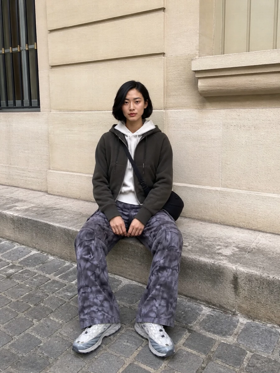 This is a city-uniform take on technical streetwear, built around the cropped Sacai hoodie and grounded by grunge-tinged Adidas cargo pants. Layering the soft off-white Y-3 hoodie underneath introduces light and dimension, while Salomon runners and the Y-3 shoulder bag keep everything fast, practical and quietly graphic. I chose the top-and-bottom route over a dress so the outerwear’s cropped, utility cut can interact with wide cargos and visible sport details rather than fighting against tailored or knit dress volumes.