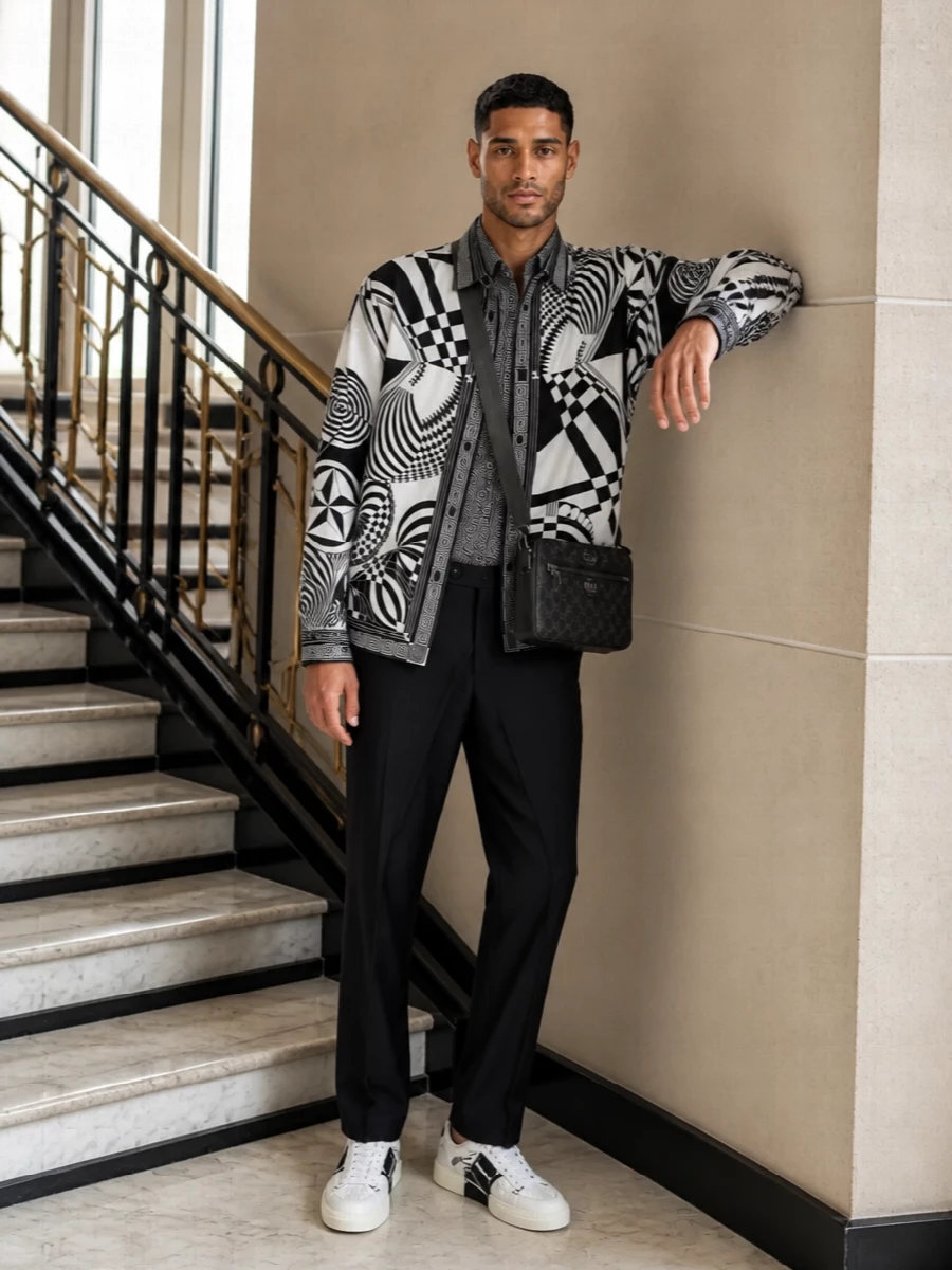 Monochrome geometry takes the lead here, with the Versace jacket and Dolce&Gabbana shirt stacking precise black‑and‑white graphics in a controlled, tailored way. Givenchy’s sharp trouser and Valentino sneakers streamline the silhouette, while the Gucci crossbody keeps the finish urban and functional. It reads like night‑ready designer streetwear that still respects suiting codes from the waist down.