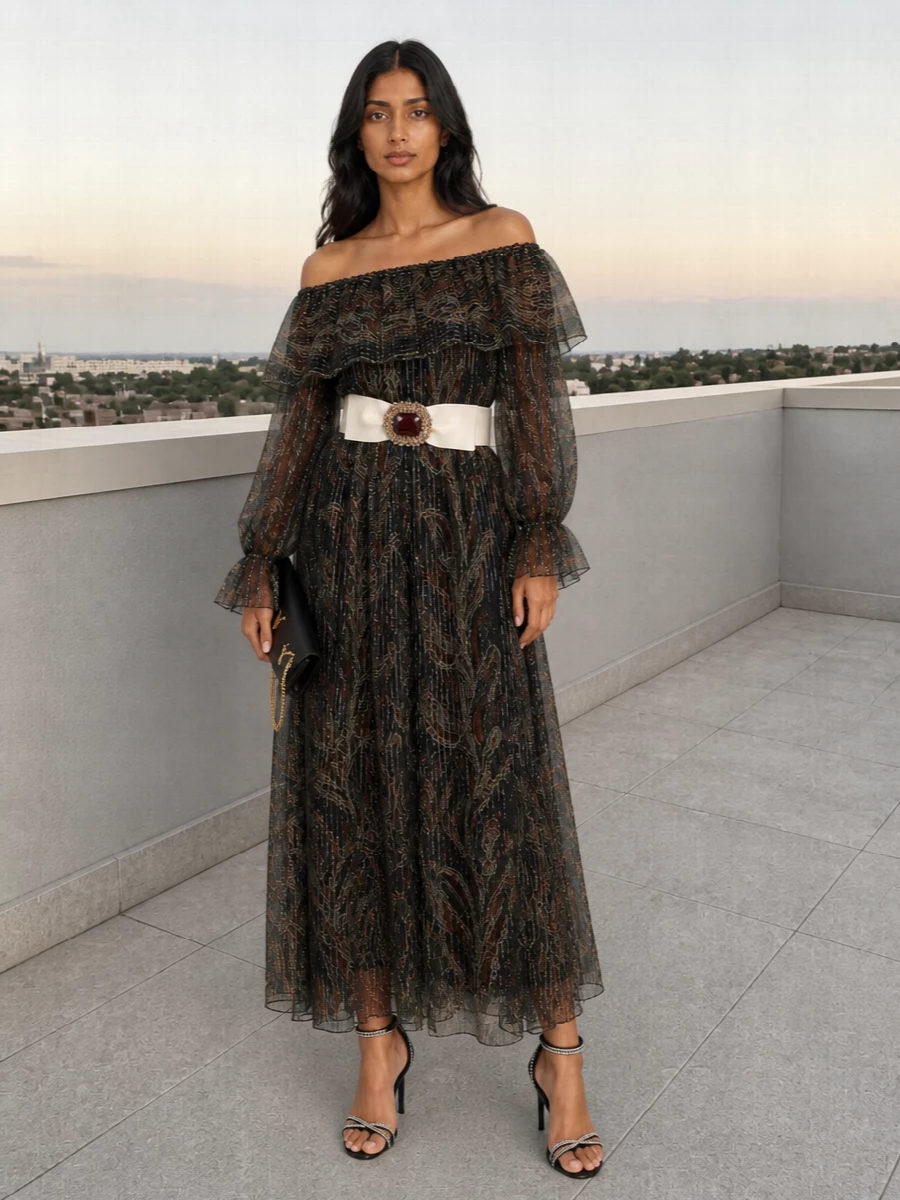 A sheer Saint Laurent paisley maxi cinched with a jeweled belt sets a romantic, slightly bohemian mood for evening. Crystal-traced black stilettos and a slim black chain clutch keep the drama focused on line, shimmer, and movement rather than color. The result is dark, fluid glamour that feels ornate yet sharply controlled.
