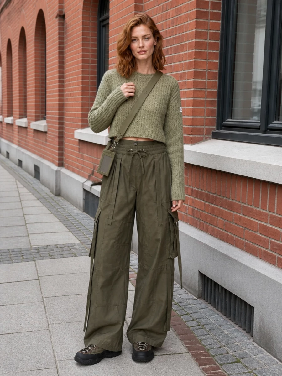 This is a city-uniform riff on trail gear: olive trek sneakers grounded with wide-leg olive cargos and a mossy cropped Margiela knit for a tonal, utilitarian column. The high waist against the boxy knit keeps proportions sharp, while the compact khaki crossbody nods to gear without feeling literal. I chose the top and bottom route over a dress to lean fully into sport-utility layering that matches the sneaker’s function and seasonality.