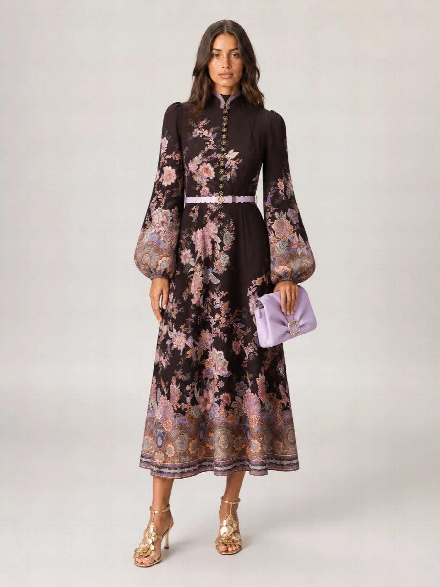 Zimmermann’s floral midi becomes evening ready with champagne-metallic sandals that catch the light and a scalloped Fendi belt cleanly defining the waist. A lilac pleated clutch lifts the mauve and lilac tones in the print, keeping the palette soft while the silhouette stays beautifully romantic and tailored enough for garden weddings or cocktail dinners.