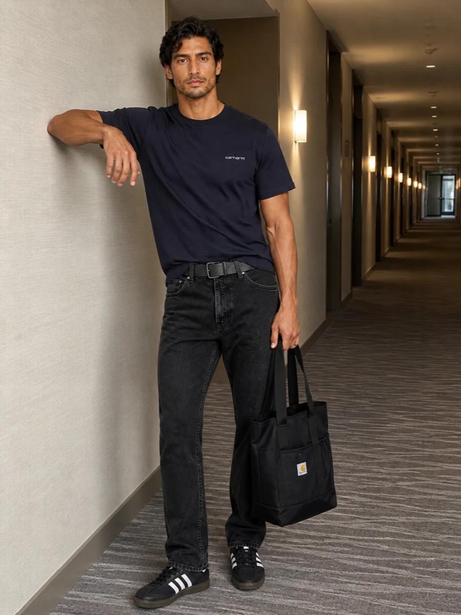 Deep navy up top and washed black down low keep this outfit firmly in that clean, utilitarian street zone. The straight-leg denim and low-profile sneakers sit relaxed but not baggy, so the silhouette stays sharp while still feeling easy. A structured tote and slim technical belt finish it with understated function rather than extra drama.