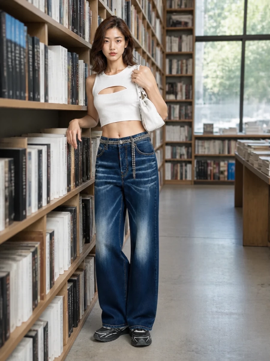A cut-out racer tank meets high-rise wide-leg denim for a sharp mix of athletic and nightlife energy. Chunky black and white sneakers keep it firmly in the streetwear realm, while the white Balenciaga mini and liquid silver chain at the waist add tight, directional detailing. The result is a clean, high-low designer combo that feels ready for late city afternoons that roll straight into neon hours.