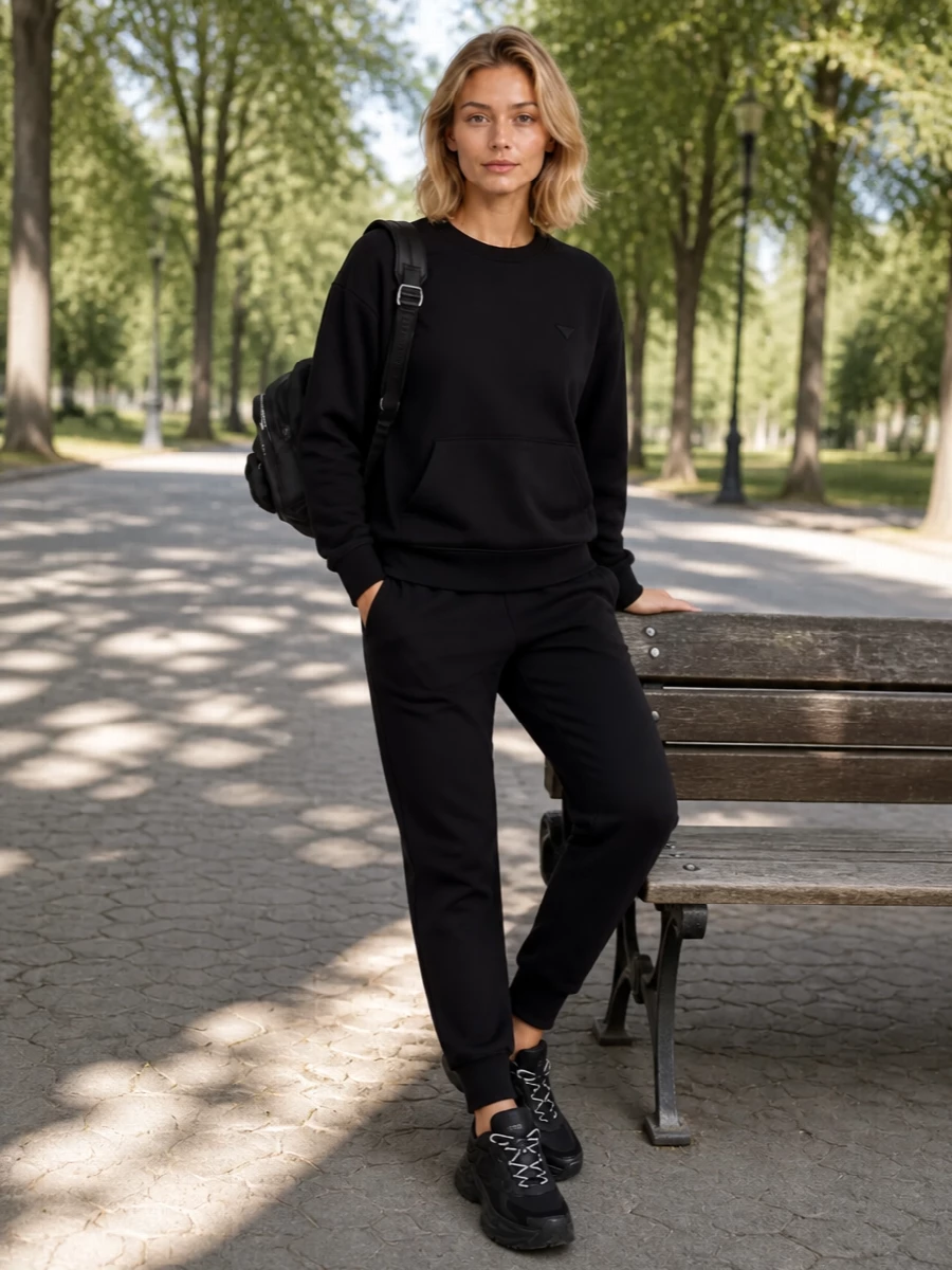 I’m taking the top and bottom route here to keep this rooted in modern athleisure that speaks directly to the sporty Moncler backpack. The Prada sweatshirt and joggers create a monochrome, quietly luxurious base that feels as considered for airport runs as for a sharp city day. Fendi’s sculptural black runner finishes the story with a technical edge that stays in the same understated, performance-driven universe rather than shouting for attention.