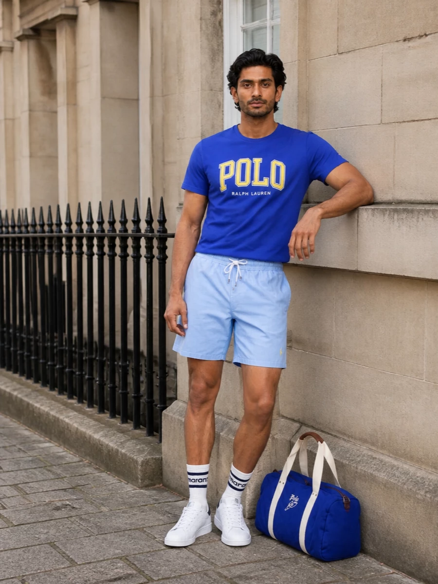 Cobalt, sky blue and sharp white create a clean campus palette that feels bright without getting loud. The relaxed shorts and court sneakers keep it firmly in sport-prep territory, perfect for warm city days or coastal weekends. Graphic brand hits stay focused in the top and bag so the rest of the outfit reads easy and pulled together.