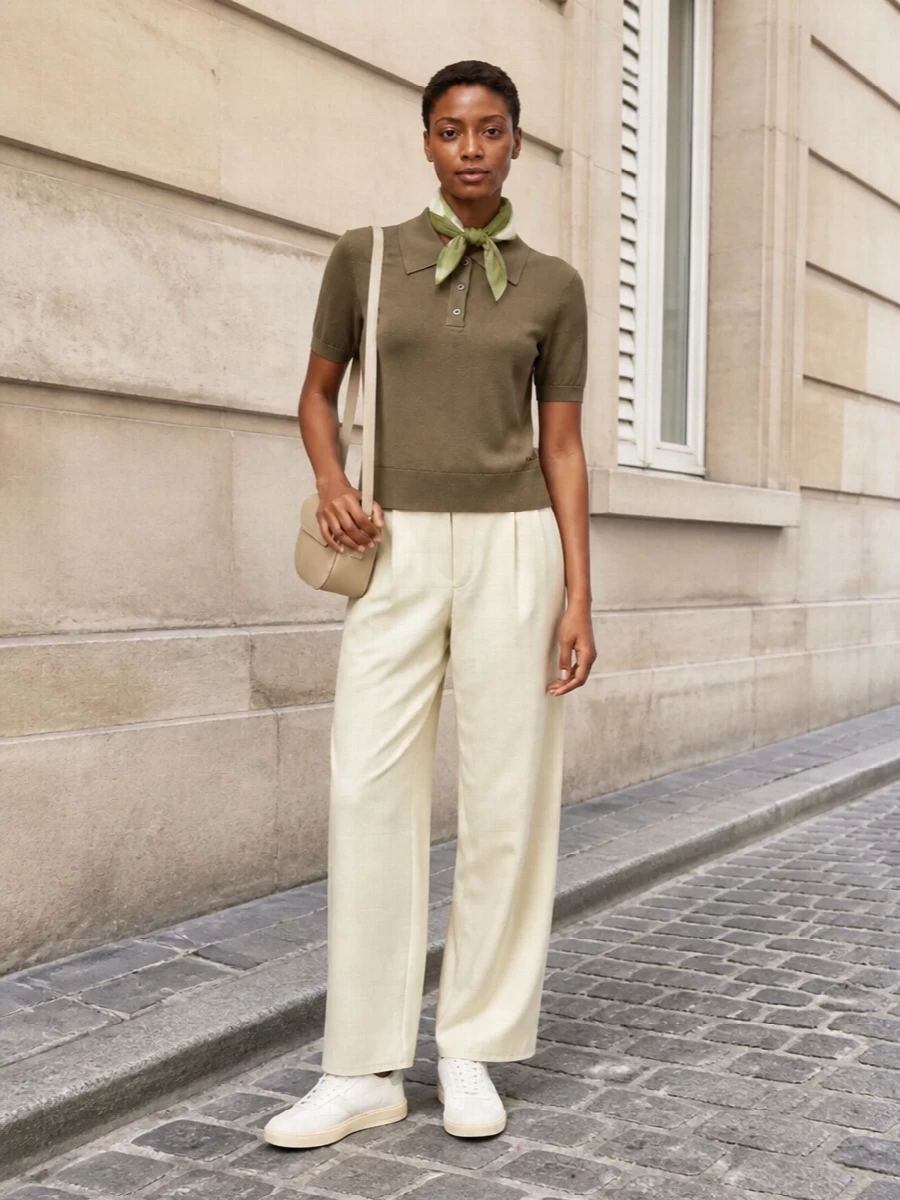 Neutral and softly tailored, this pairing leans into A.P.C.’s quiet ease with an olive knit grounded by fluid buttercream pleats. Pale sneakers and a curved light bag keep the palette airy, while an olive scarf ties the tones together with a gentle preppy nod. It is an easy city uniform for warm days when you want polish without sharp edges.