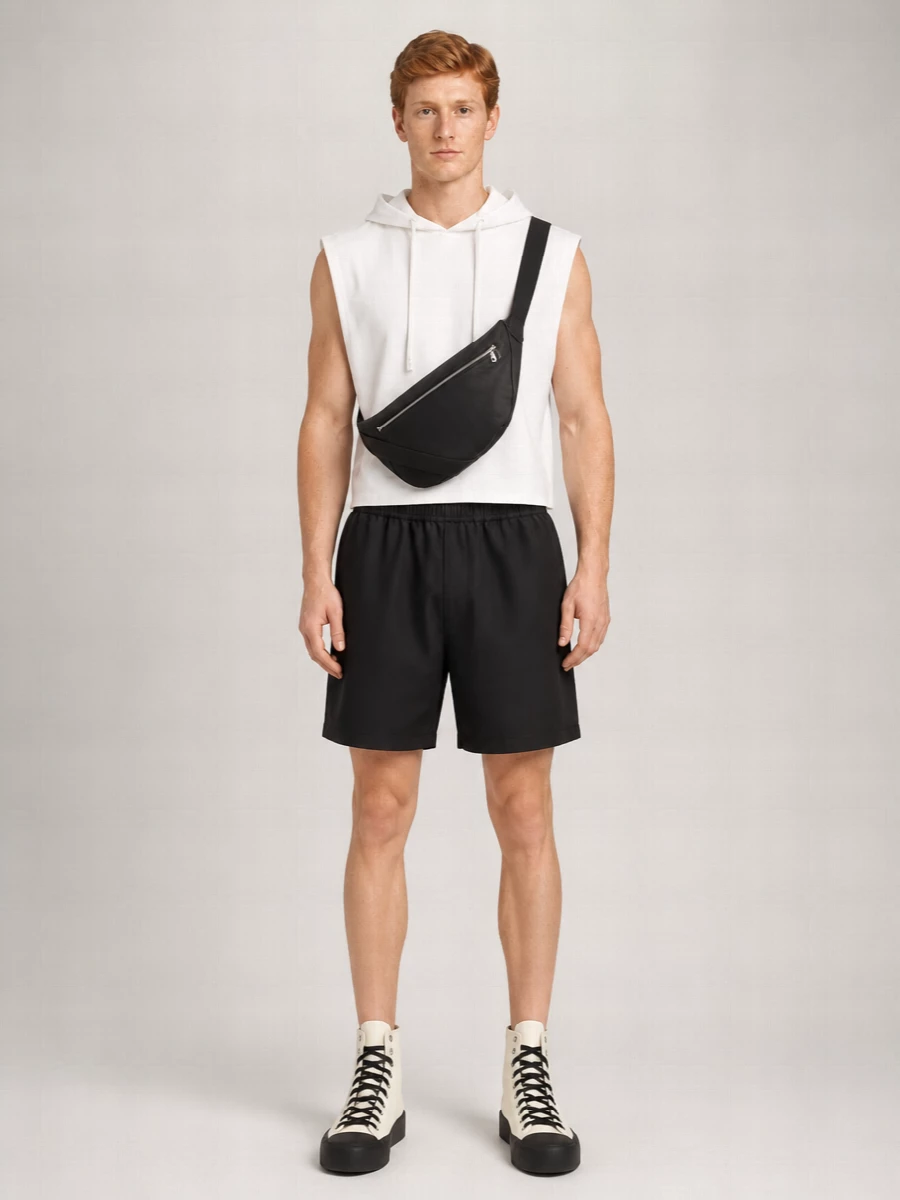 A sharp cropped white hoodie sits over disciplined black shorts for a clean, athletic street uniform. Off-white high-top sneakers echo the top while the black sole and sling bag lock in a graphic monochrome line. The whole combo reads controlled and minimal, with just enough attitude to feel intentional rather than basic.