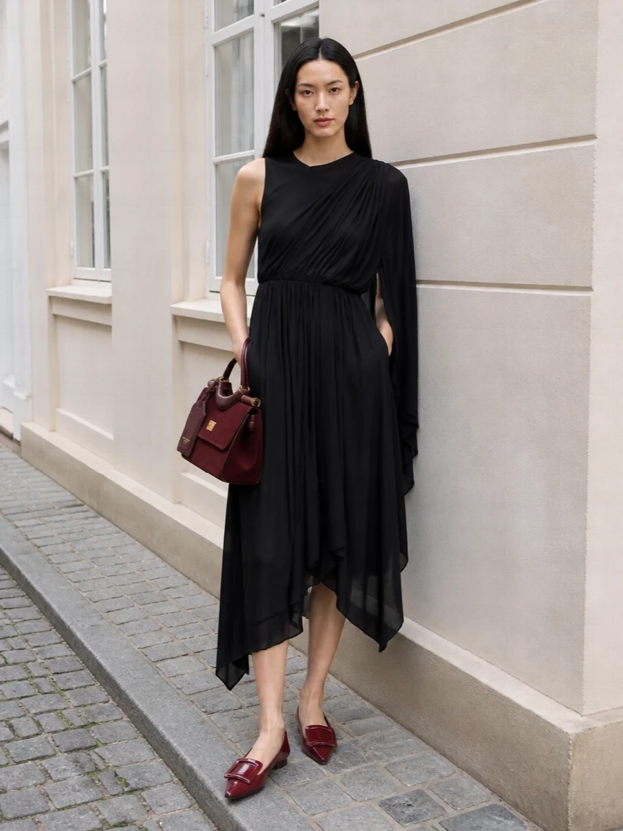 Anchoring with the black Balenciaga draped midi keeps the story rigorously minimalist, letting the burgundy Dolce&Gabbana bag read as a single, rich accent. The Roger Vivier pointed ballerinas echo the bag’s tone and refined hardware, holding the formality at polished evening while staying understated and wearable. Choosing the dress route over separates keeps the silhouette long and fluid, which suits the bag’s structured shape and quietly dramatic character best.