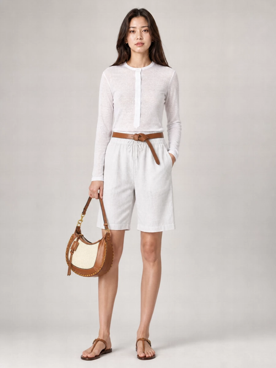 Soft white and light grey set a calm base, with the sheer long-sleeve tee echoing the shorts’ airy movement. Taupe leather sandals and a cream-and-tan hobo add warm texture, while a knotted belt gives just enough definition to keep the relaxed silhouette intentional. It is an easy warm-weather outfit for city days, travel, or coastal weekends that still feels quietly polished.